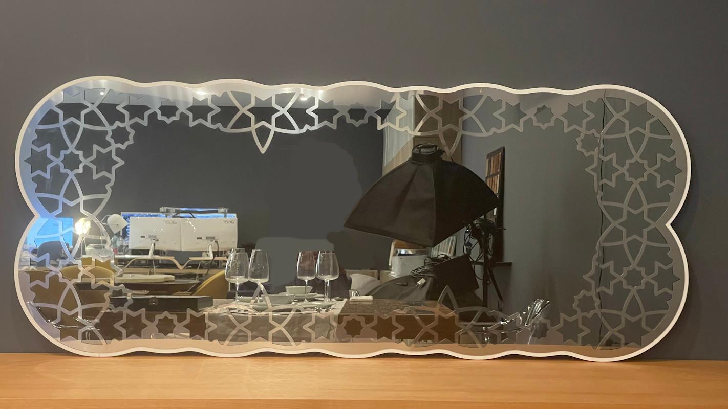 The Arabesque Mirror is mastercrafted using a thick piece of stainless steel polished by hand. The back is made of white lacquered wood. It can be put on a sideboard or attached to a wall. The stainless steel has a gorgeous laser-cut Arabic pattern.
