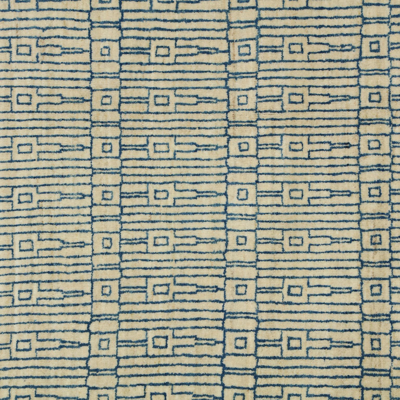 This modern carpet, with an architectural design in blue on a cream background, utilizes handspun wool and vegetable dyes. This pure wool area rug, created by the artisans of Orley Shabahang, is approximately 8' x 10', a versatile size perfect for