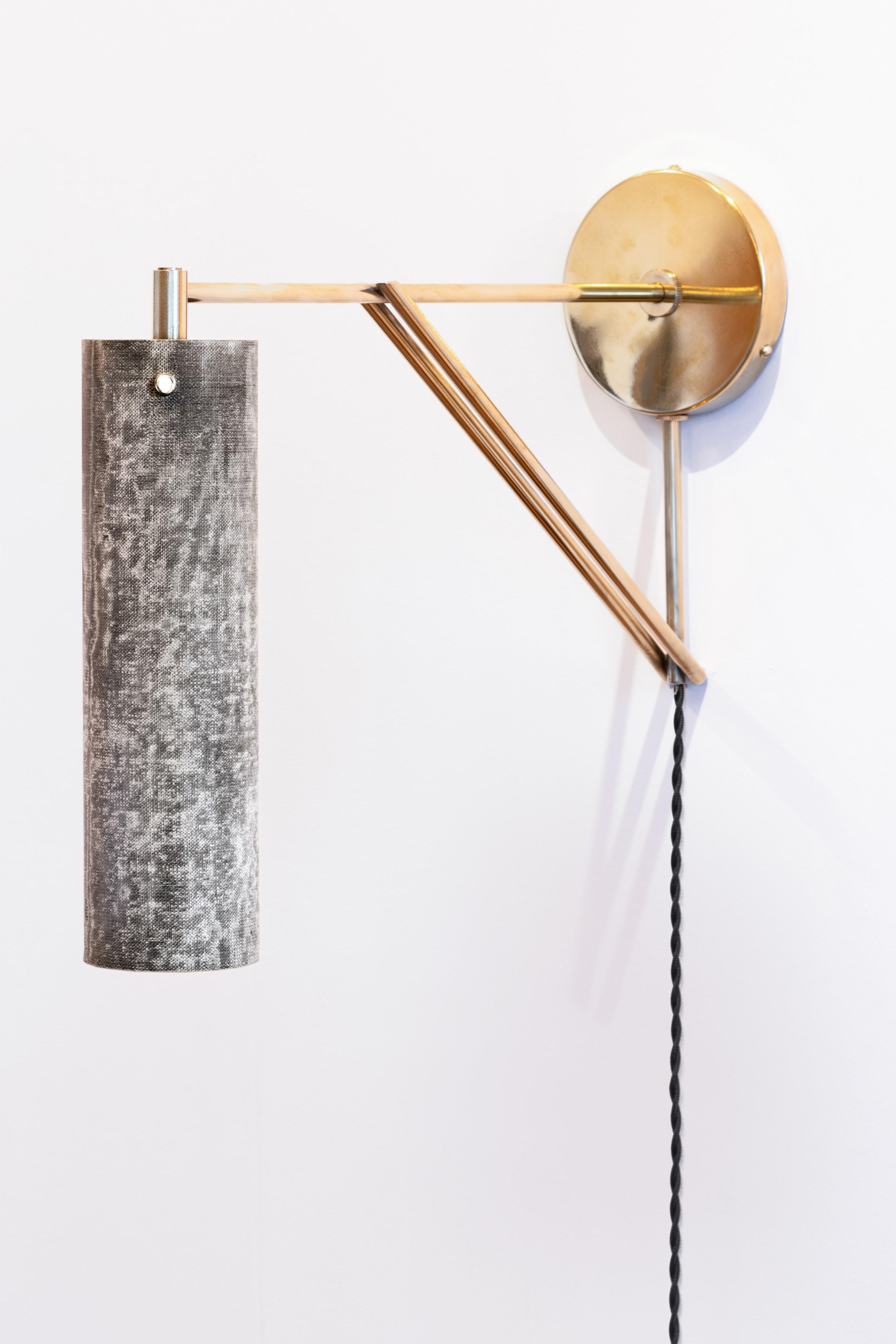 La Tikal Armed Sconce è riconoscibile per il nostro caratteristico paralume in micarta, realizzato a mano in lino e resina. 
Il paralume leggero produce una luce soffusa e un interesse visivo sia da acceso che da spento.  Il paralume cilindrico