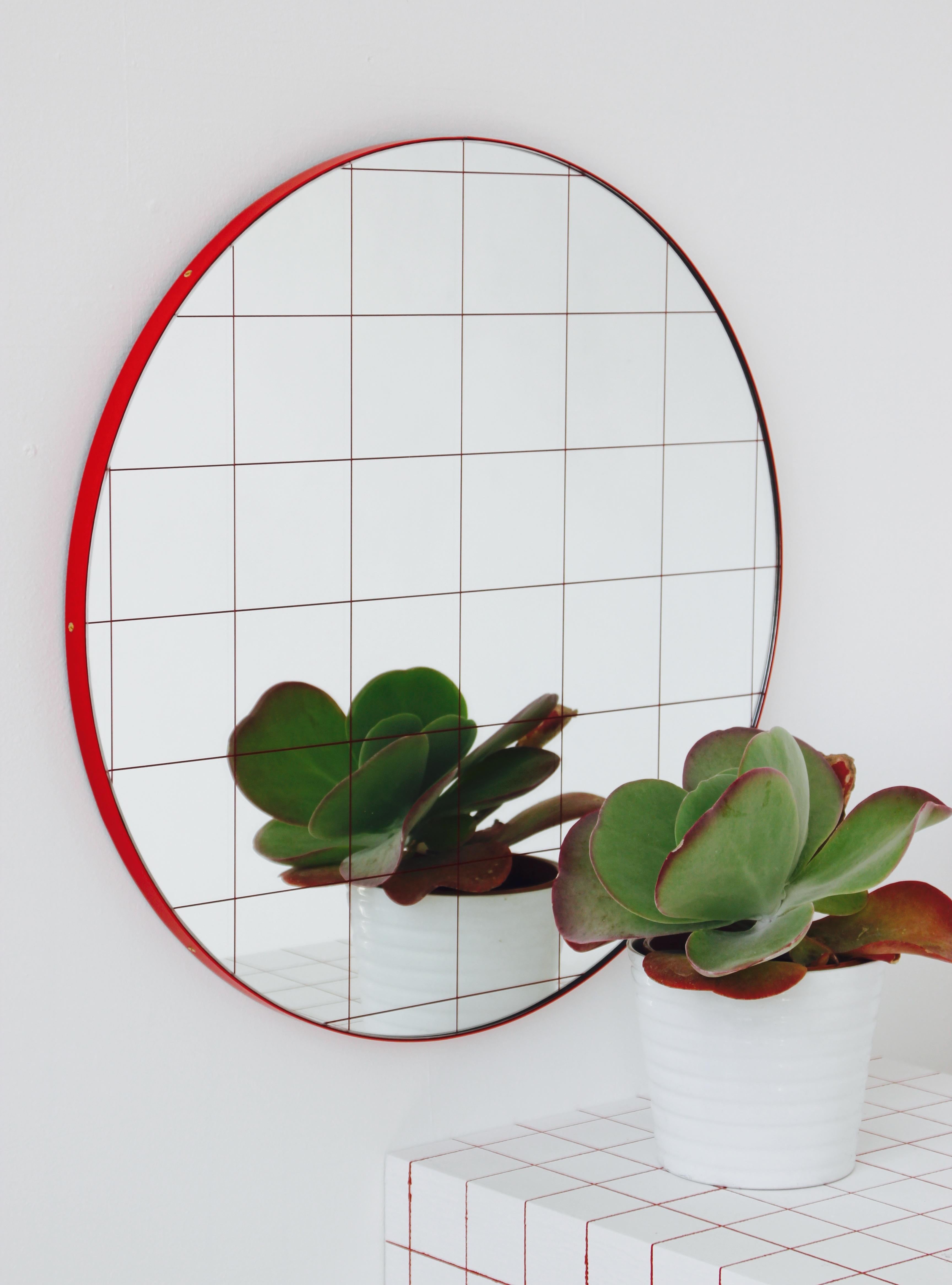 Modern decorative round Orbis mirror with a red grid and a powder coated red frame. Designed and handcrafted in London, UK.

Small and regular sizes (40 and 50cm) are fitted with a practical brass D ring hook. A Z bar system is available for all