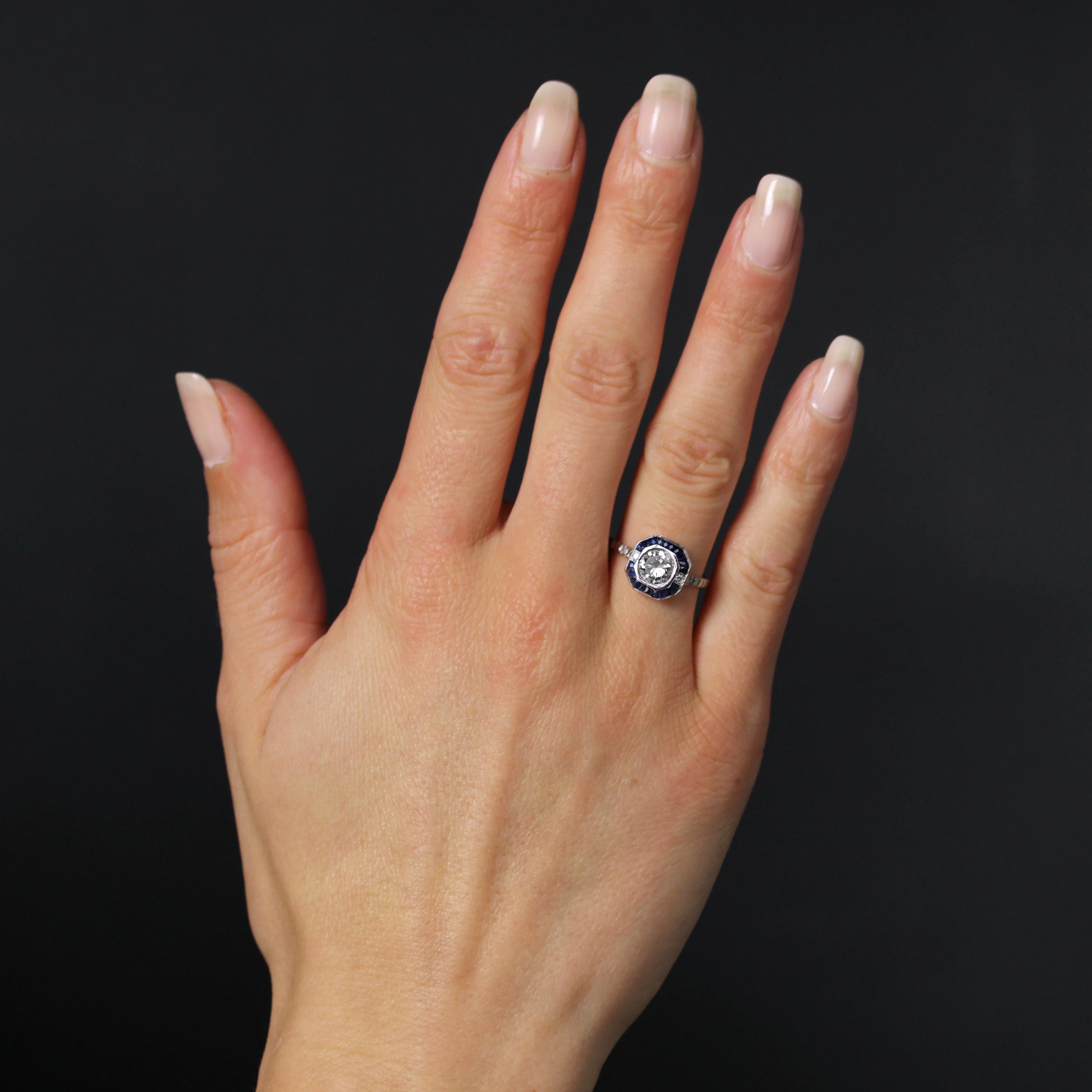 Ring in platinum.
Octagonal- shaped, this charming art deco ring is adorned with a brilliant-cut diamond in octagonal setting, shouldered with two diamonds. The rest of the border is decorated with calibrated blue sapphires. On both sides the start