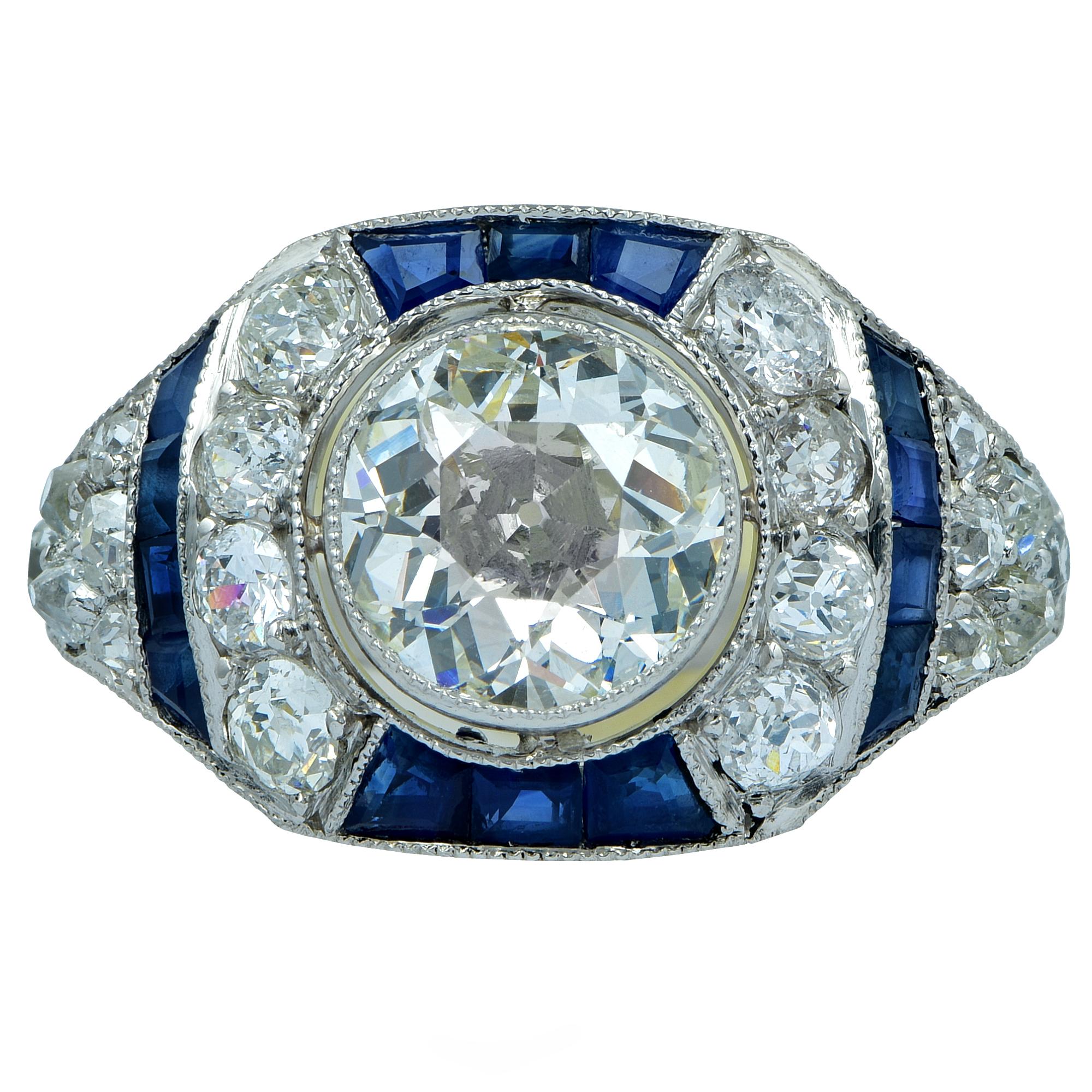 Platinum ring featuring a 1.71ct European cut diamond J color and VS clarity surrounded by 1.15cts of European cut diamonds and 14 royal blue sapphires weighing .70cts total. 

Our pieces are all accompanied by an appraisal performed by one of our