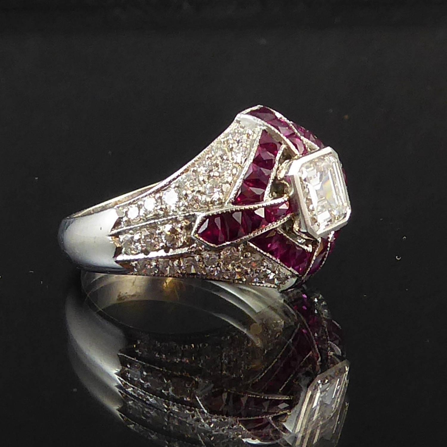 A stunning Art Deco style diamond and ruby cluster design cocktail ring centring on a square emerald cut diamond approx. 0.62ct in a raised rub-over octagonal setting to a curved boule head full set with a cross and off-set square surround of 34