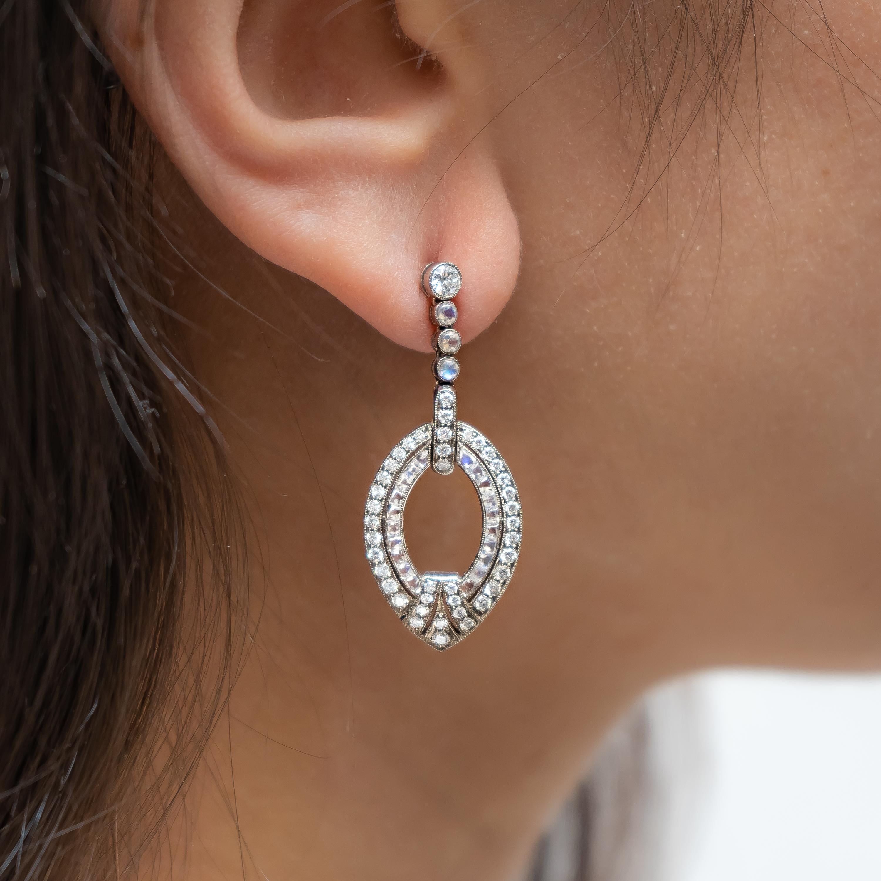 Un paio di orecchini a goccia con diamanti e pietre di luna in stile Art Déco moderno, con diamanti rotondi taglio brillante per un peso totale di 1,03 carati e pietre di luna per un peso totale di 3,50 carati, con una fila di diamanti e pietre di