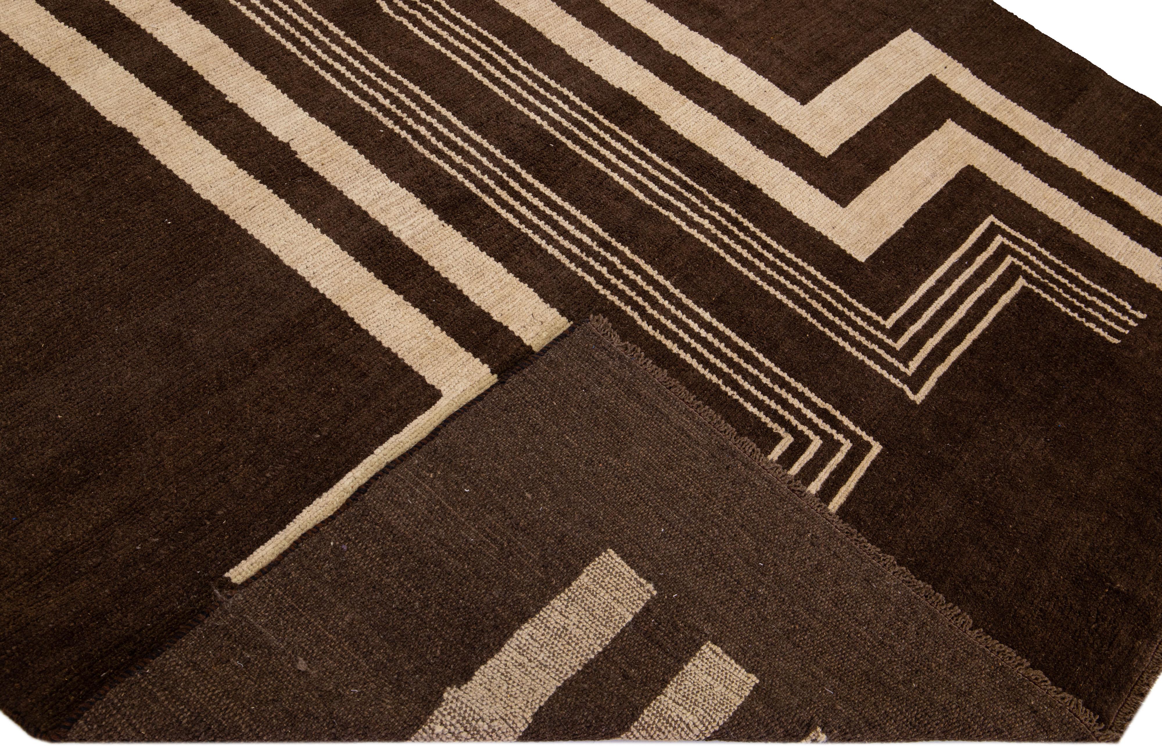 This Beautiful Modern Art Deco handmade wool rug makes part of our Northwest collection and features a brown color field and beige accents in a gorgeous geometric tribal design.

This rug measures: 7'3
