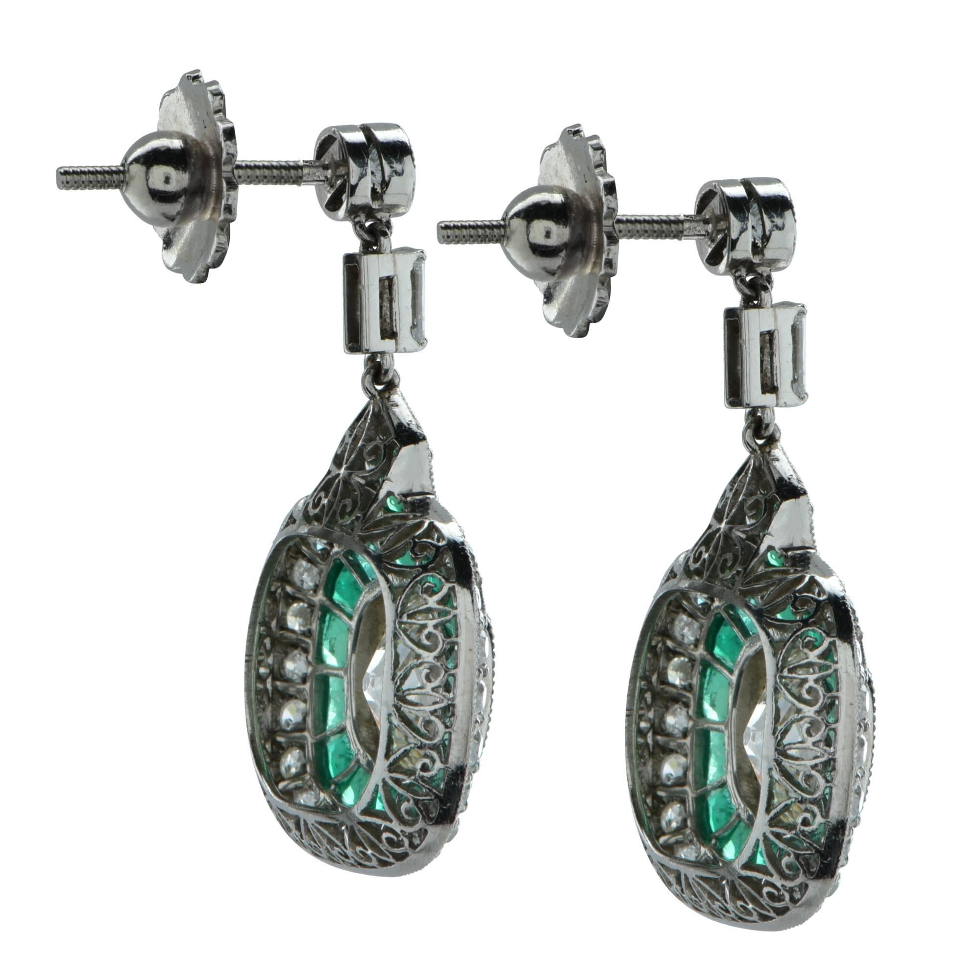 Stunning modern Art Deco style  articulating dangle earrings featuring 2 antique old mine cut diamonds weighing approximately 3.2 carats total, H color, SI clarity, set in platinum and framed with milgrain. The diamonds rest on a bed of 30 vivid