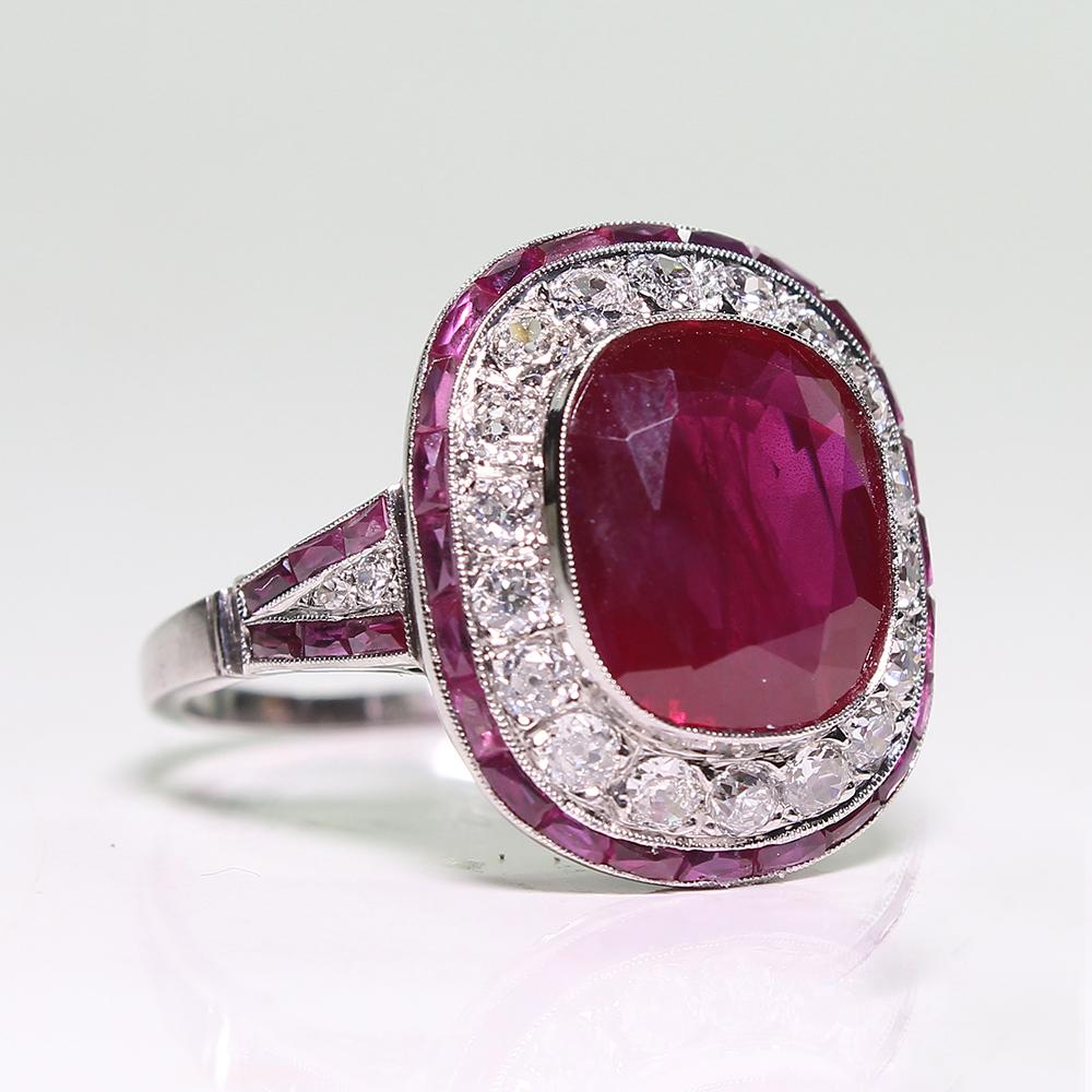 Period: Art Deco (1920-1935)
Composition: Platinum

Stones:
•	1 natural cushion cut Burma ruby that weighs 5.68ctw. (11.18mm by 9.53mm by 4.9mm)
•	22 diamonds of G-VS1 quality that weigh 1.10ctw. 
•	34 natural calibrated cut rubies that weigh