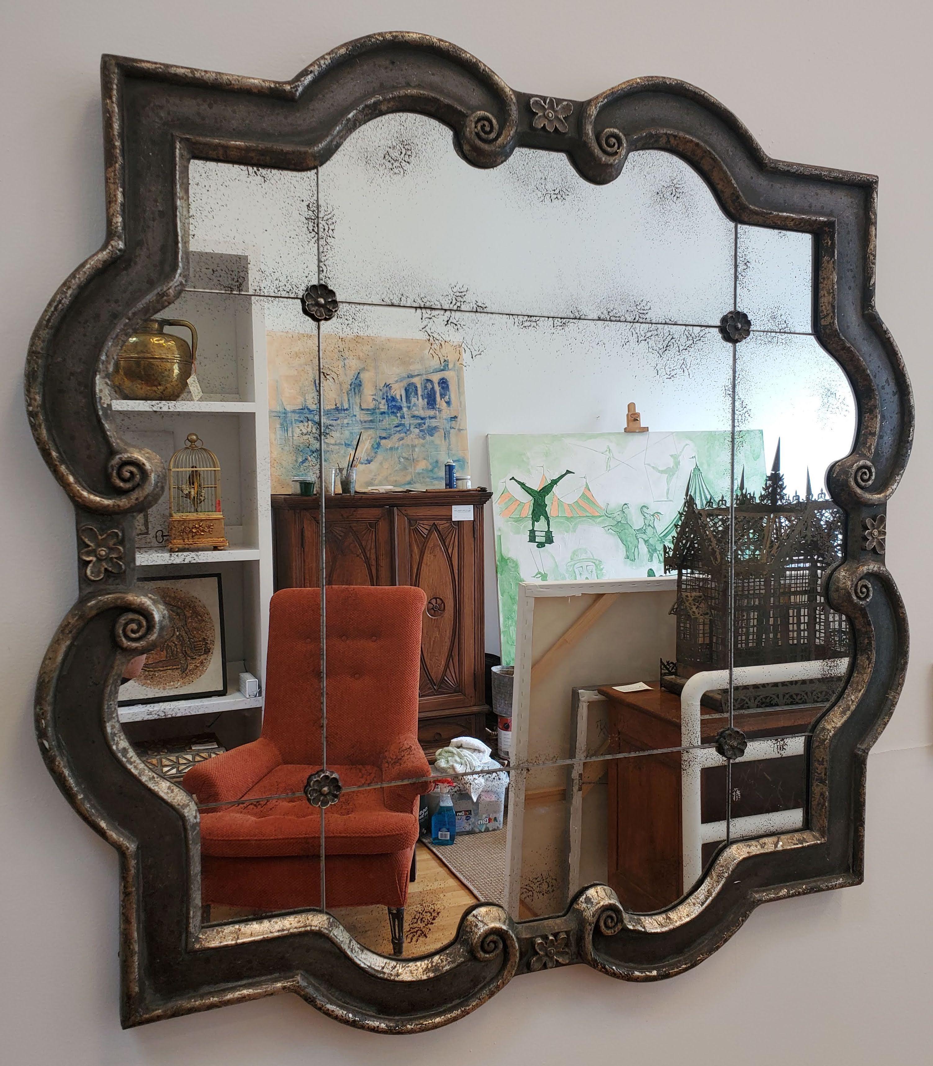 This modern silver gilt mirror will give your space a reflection of Art Deco style. Carved moulded frame with sectional mirror and four rosettes and artificially worn mirror gives it well loved look that will fit in with your antiques. 
Measures: