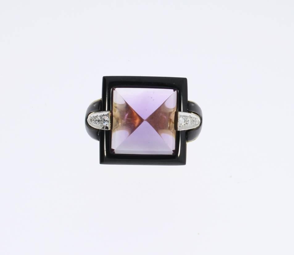 German Art Deco style. Square, slightly elevated front, in the centre sugarloaf amethyst weighing circa 10,00 carats, flanked on each side by 8 brilliant-cut diamonds with a total weight of 0,46 ct. VS, wesselton. With onyx frame. Mounted in 18