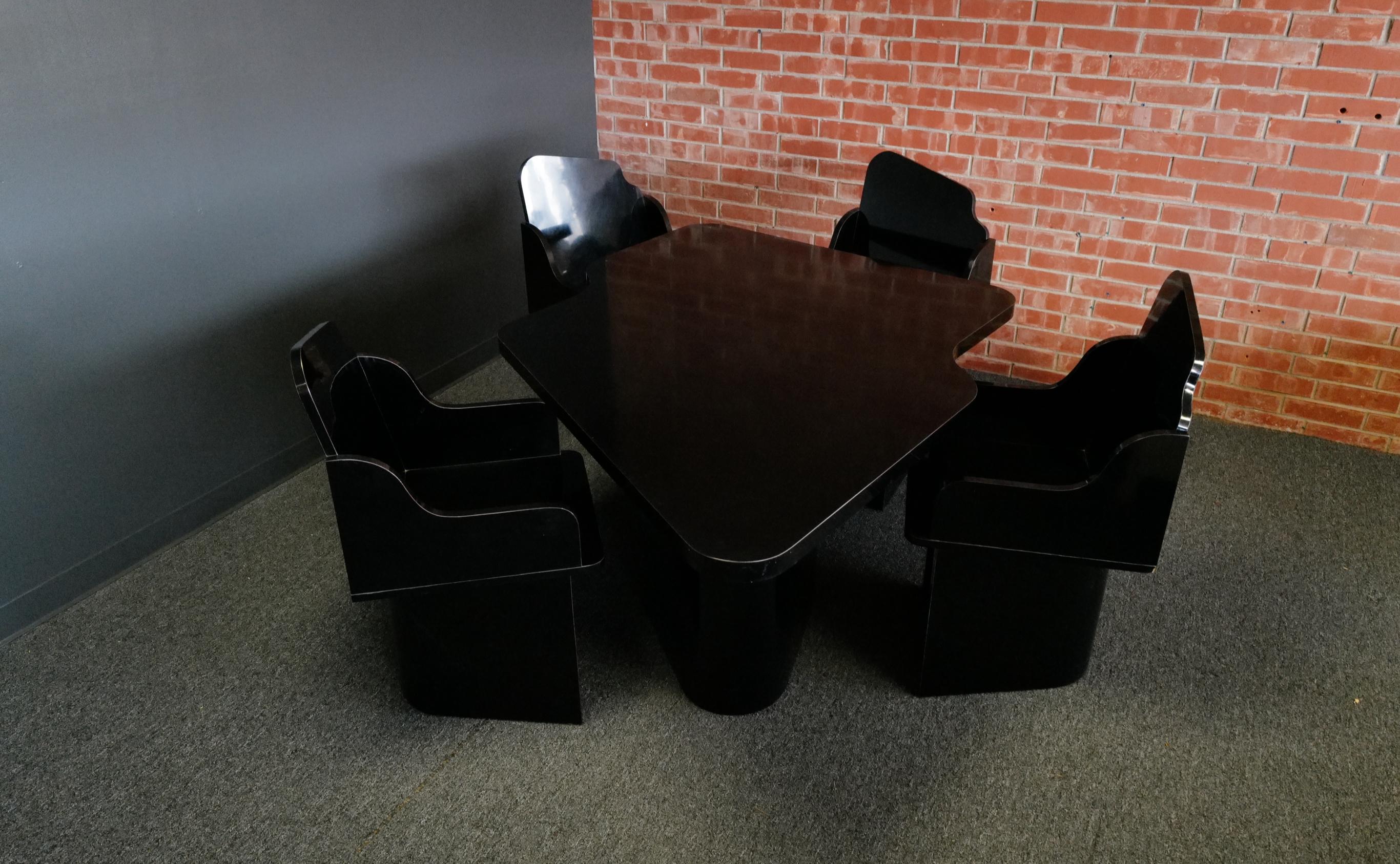 Das Esszimmer-Ensemble besticht durch seine Launenhaftigkeit: Ein schwarzer, organisch geformter Tisch im Formica-Stil wird von vier charmanten Stühlen begleitet. Die verspielten Konturen des Tisches bringen einen Hauch von Fantasie in den