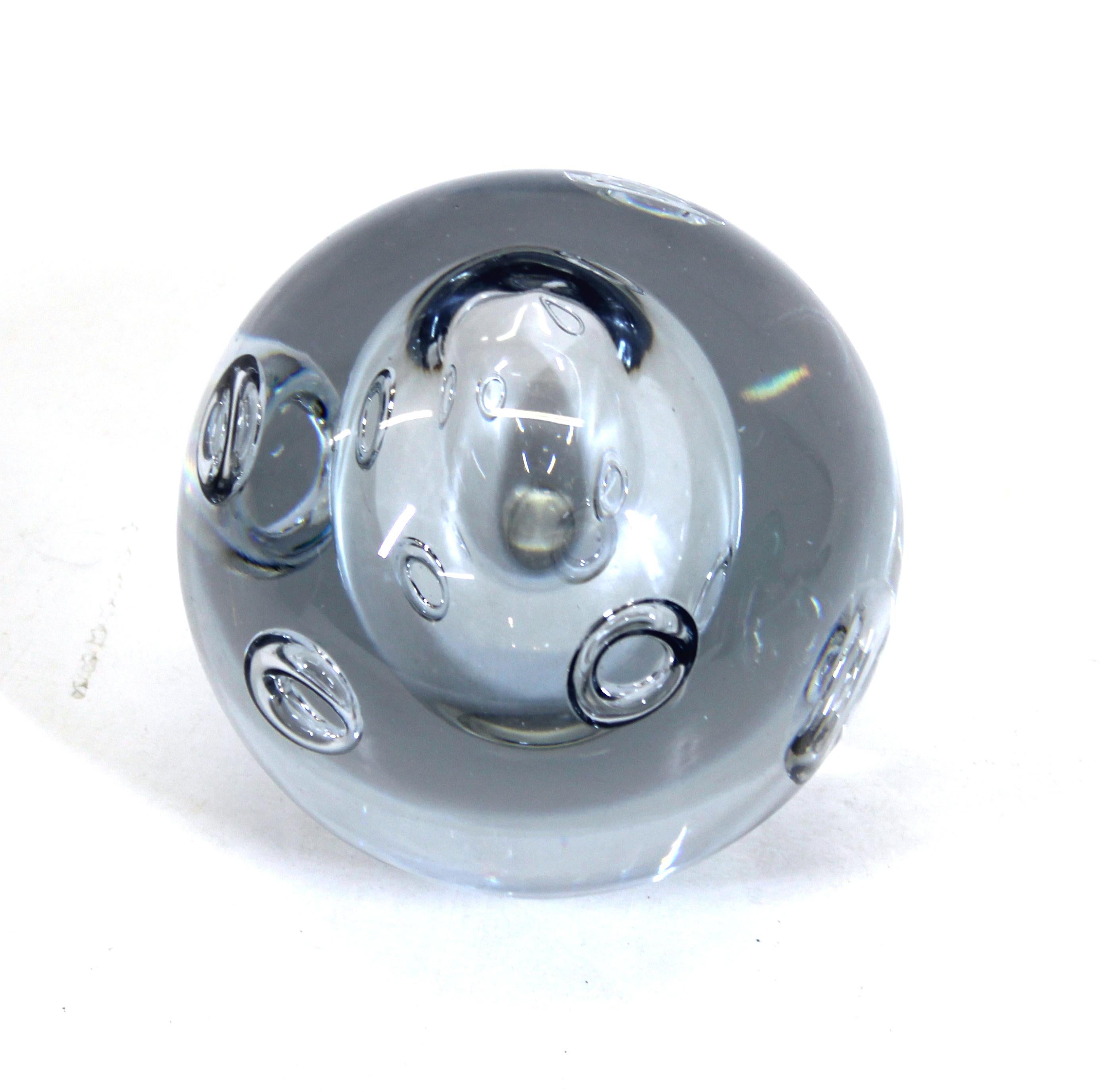 Modern art glass paperweight sphere with controlled bubble rings surrounding a larger central bubble, signed illegibly on bottom.