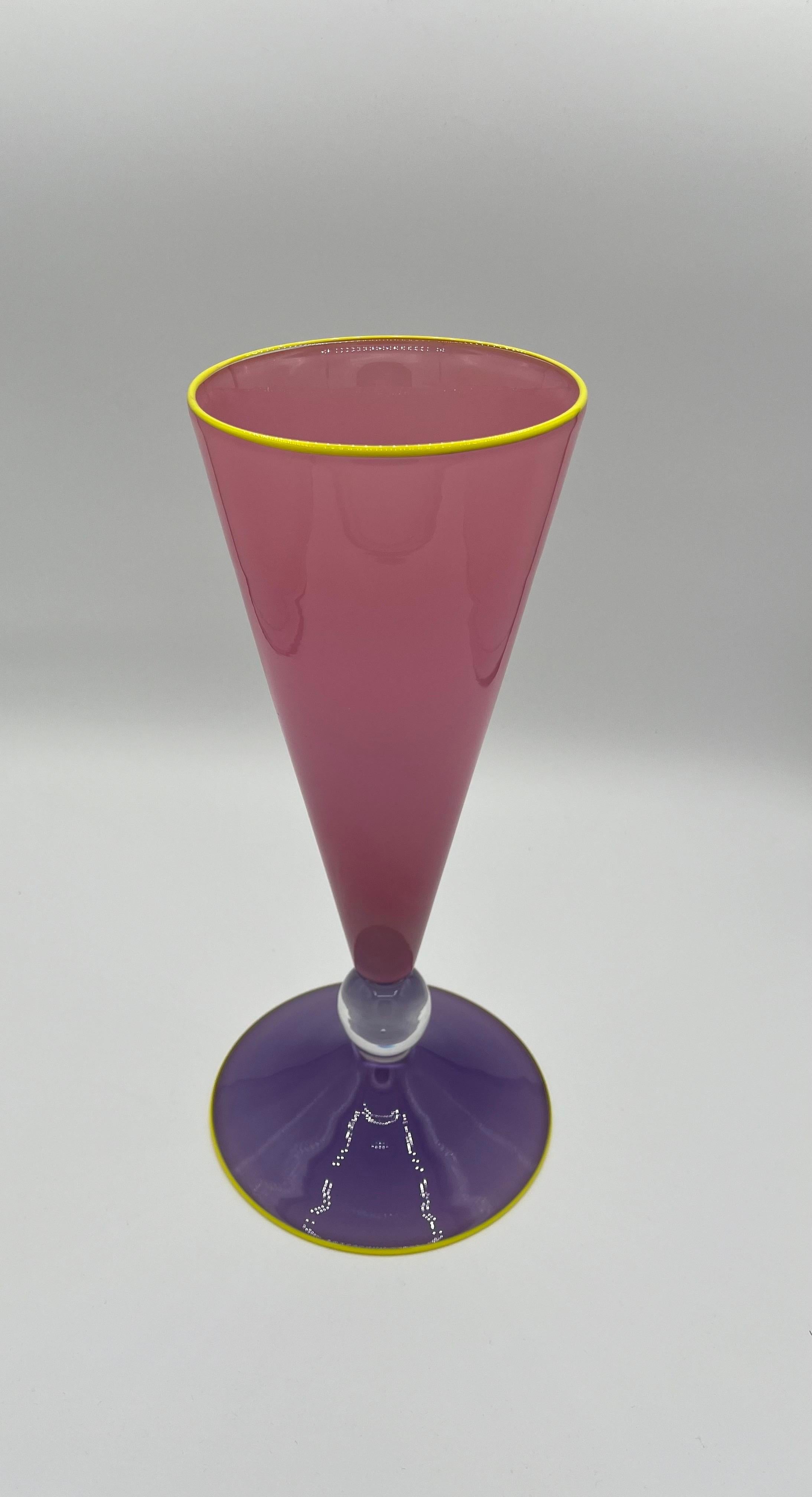 Des couleurs et une forme époustouflantes. Verre d'art soufflé dans une magnifique base violette, une boule transparente soutenant une élégante partie supérieure effilée de couleur rose. La base et la partie supérieure sont garnies de jaune vif. Un