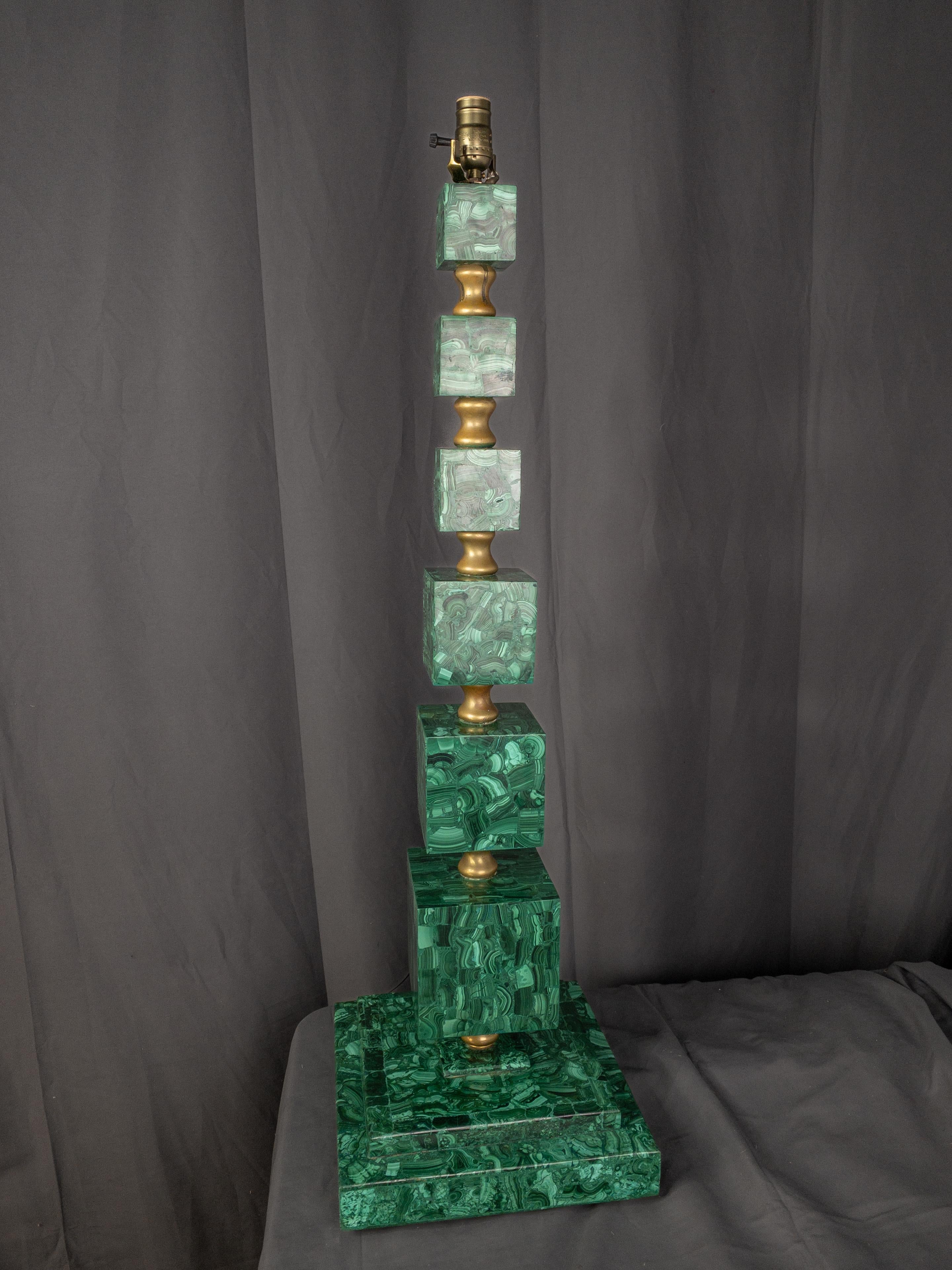 The Modern Art Malachite and Brass Tessellated Lamp is a striking embodiment of contemporary sophistication. Its design seamlessly marries luxurious elements: the rich allure of malachite and the opulent warmth of brass. The lamp's tessellated