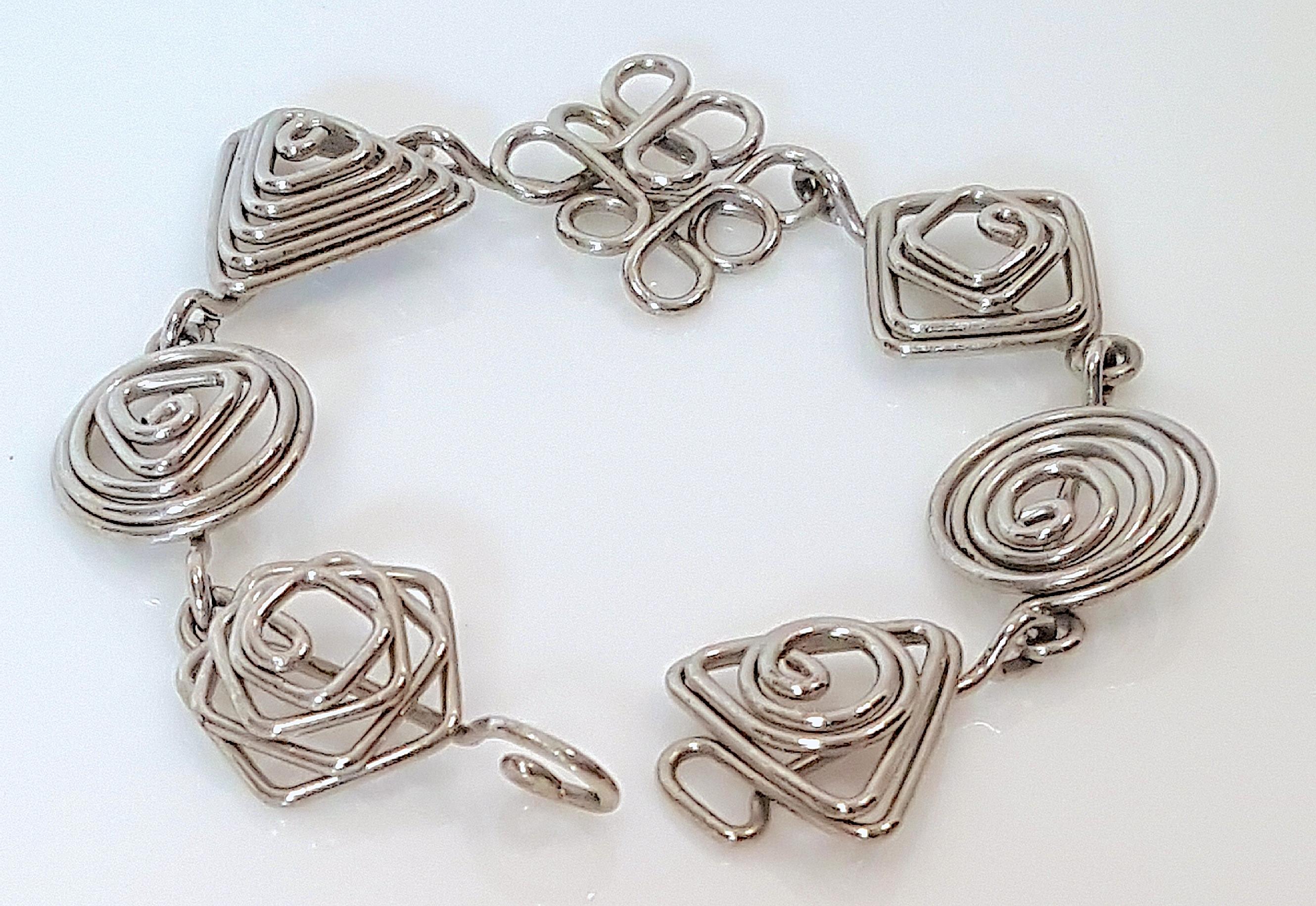 This modern one-of-a-kind geometric-spirals seven-link bracelet was expertly handmade from silver wire dating to the 20th Century in a style not earlier than Art Deco. There are no marks or jewelry techniques other than from the pliers used to bend