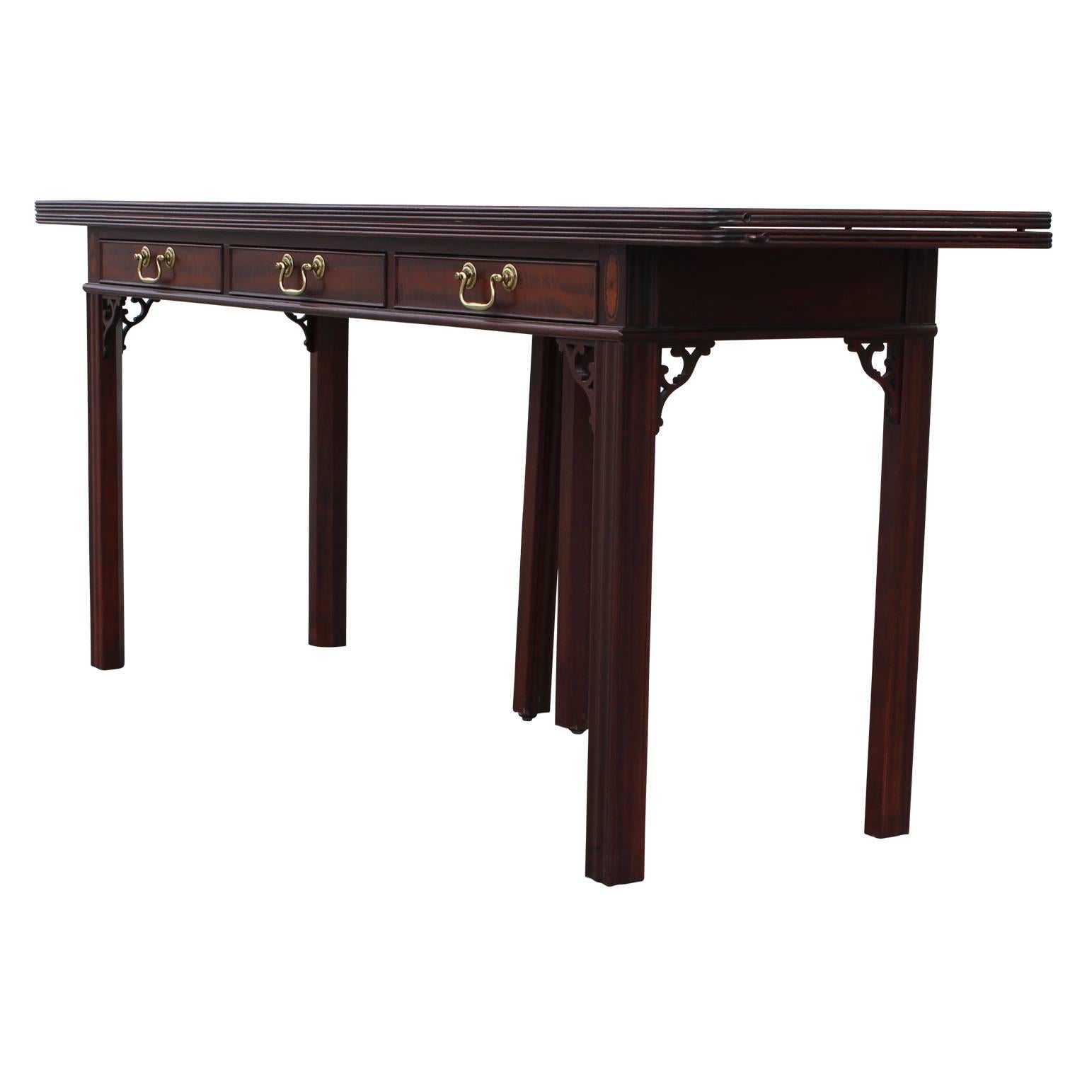 Modern Baker flip-top console table or desk with three drawers and brass hardware. Made from a gorgeous Mahogany. 

Measures: Total depth with top folded out 38 inches.