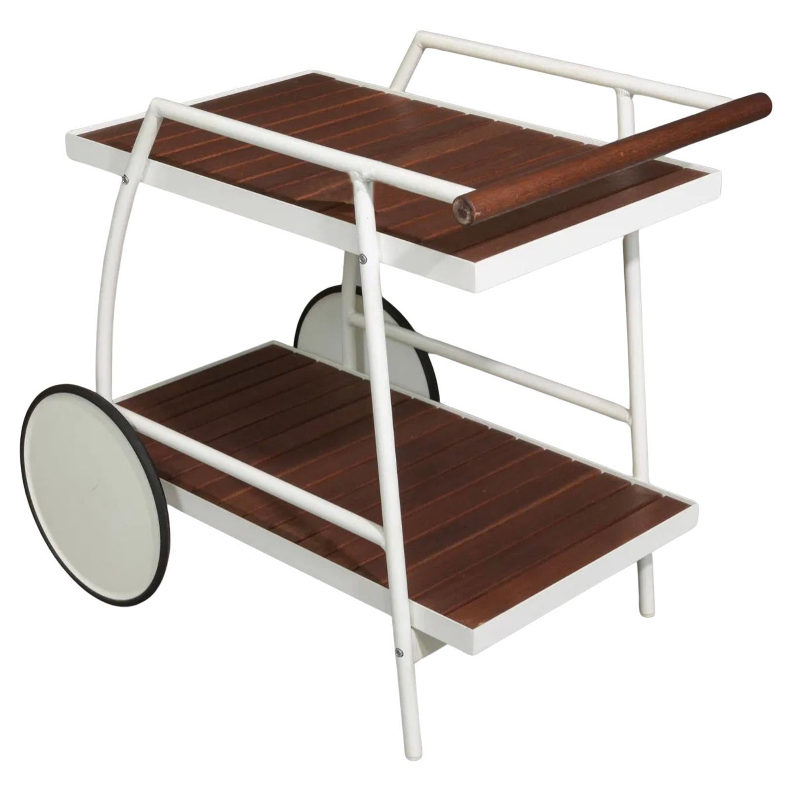 Moderno Carrito de bar o carrito de té de interior o exterior junto a la piscina en blanco y madera. Hacia 1990 o 1980. Armazón de acero blanco con recubrimiento en polvo y lamas de madera dura exótica. Tiene (2) ruedas blancas grandes con bandas de