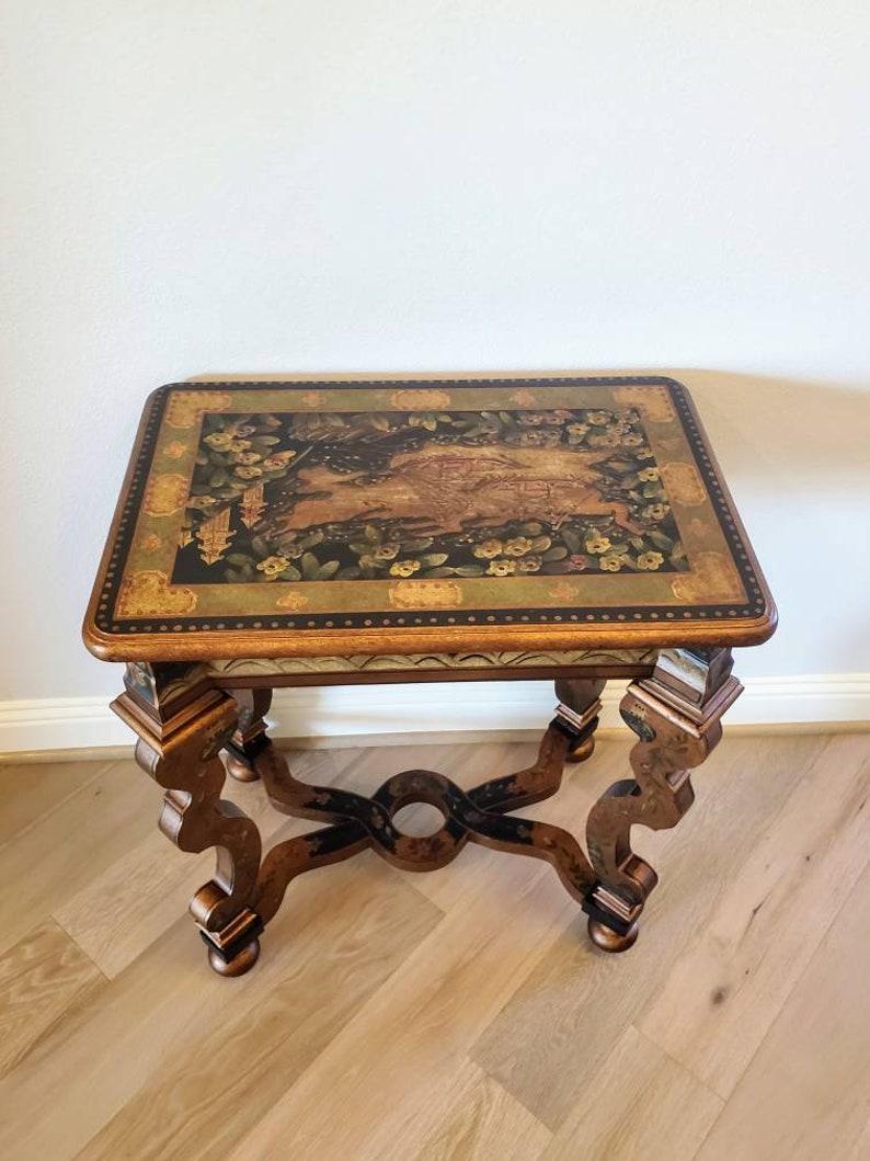 A rare hand painted ebonized parcel bronze gilt Baroque Chinoiserie Revival side table. Exceptionally executed, the contemporary antique reproduction is styled after late 17th / early 18th century European Baroque furniture. Having an X-form