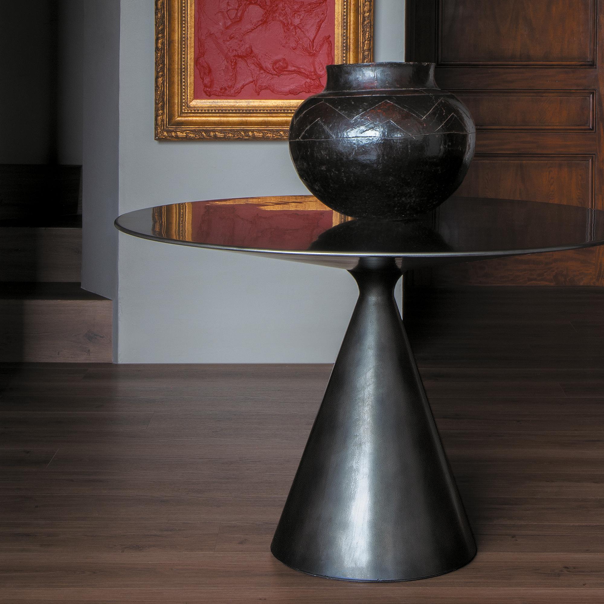 This standout piece is modern yet simple. It has a conical base which joins seamlessly with the sleek cover. The finish looks like polished metal but is completely made of wood. This sophisticated and versatile piece can be placed in many different