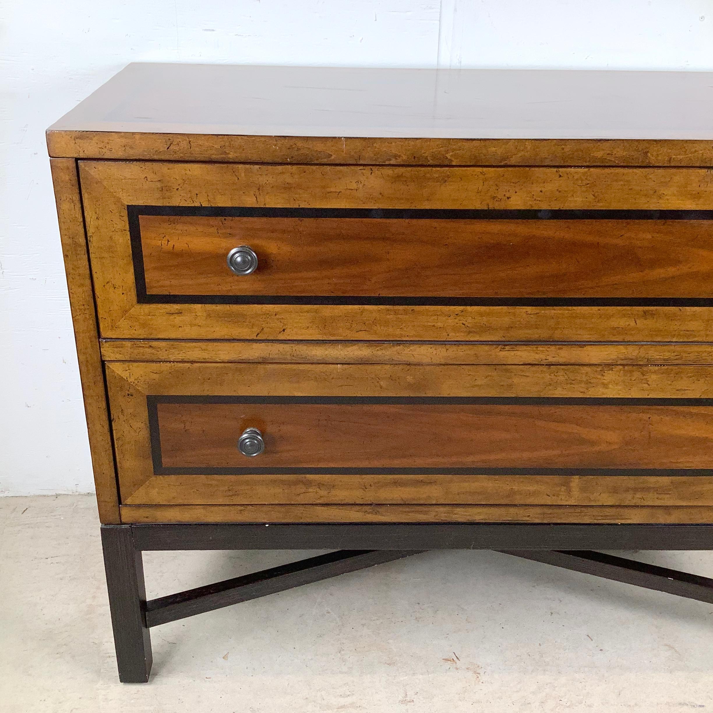 Questa cassapanca classica e moderna di Bassett riunisce ricche tonalità di legno, linee semplici e una base splendidamente strutturata. L'intarsio incorniciato sui frontali dei cassetti e sul piano aggiunge profondità e definizione, conferendo al