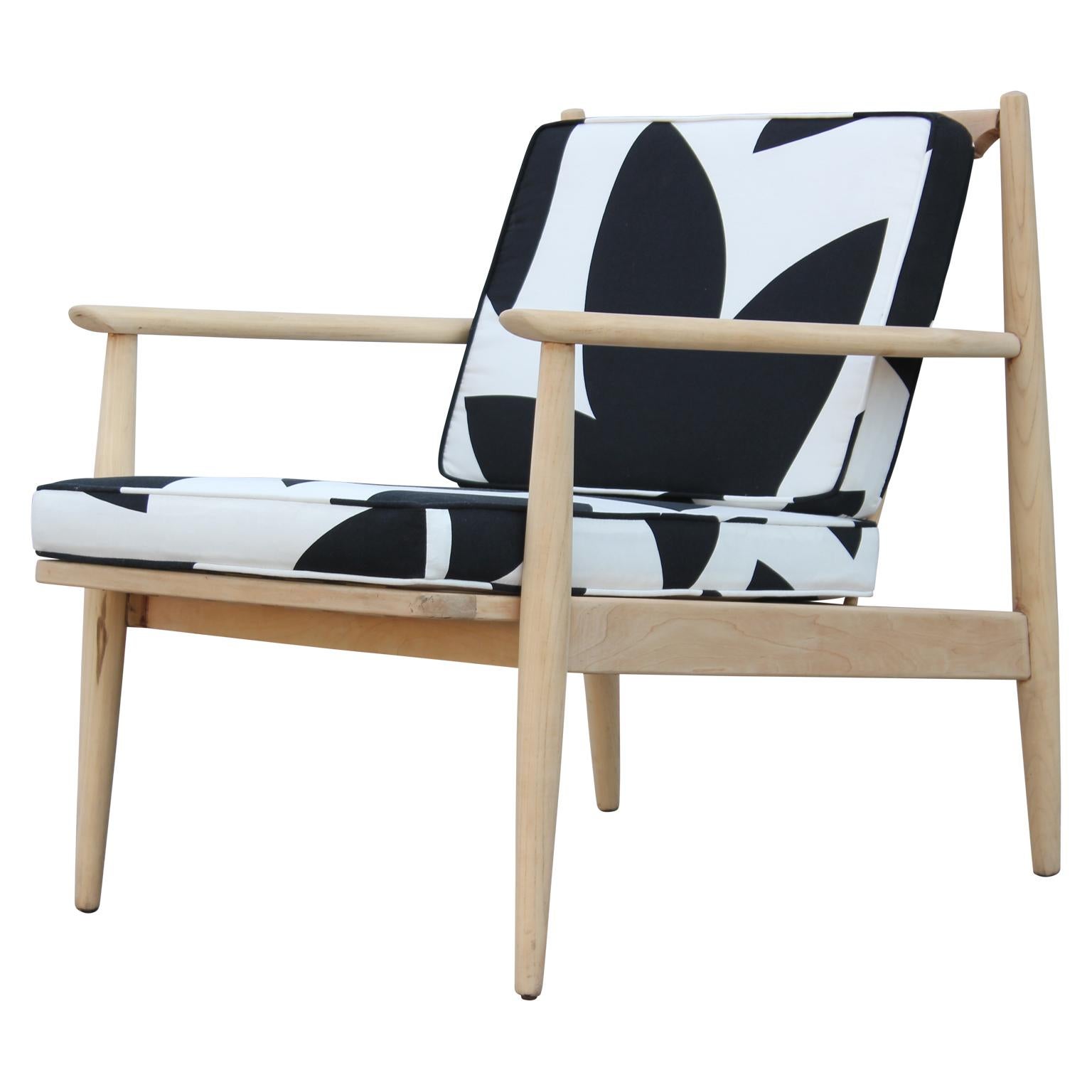A beautiful modern Danish style lounge chair featuring a playful geometric black and white pattern fabric and a custom light walnut finish. By Baumritter.