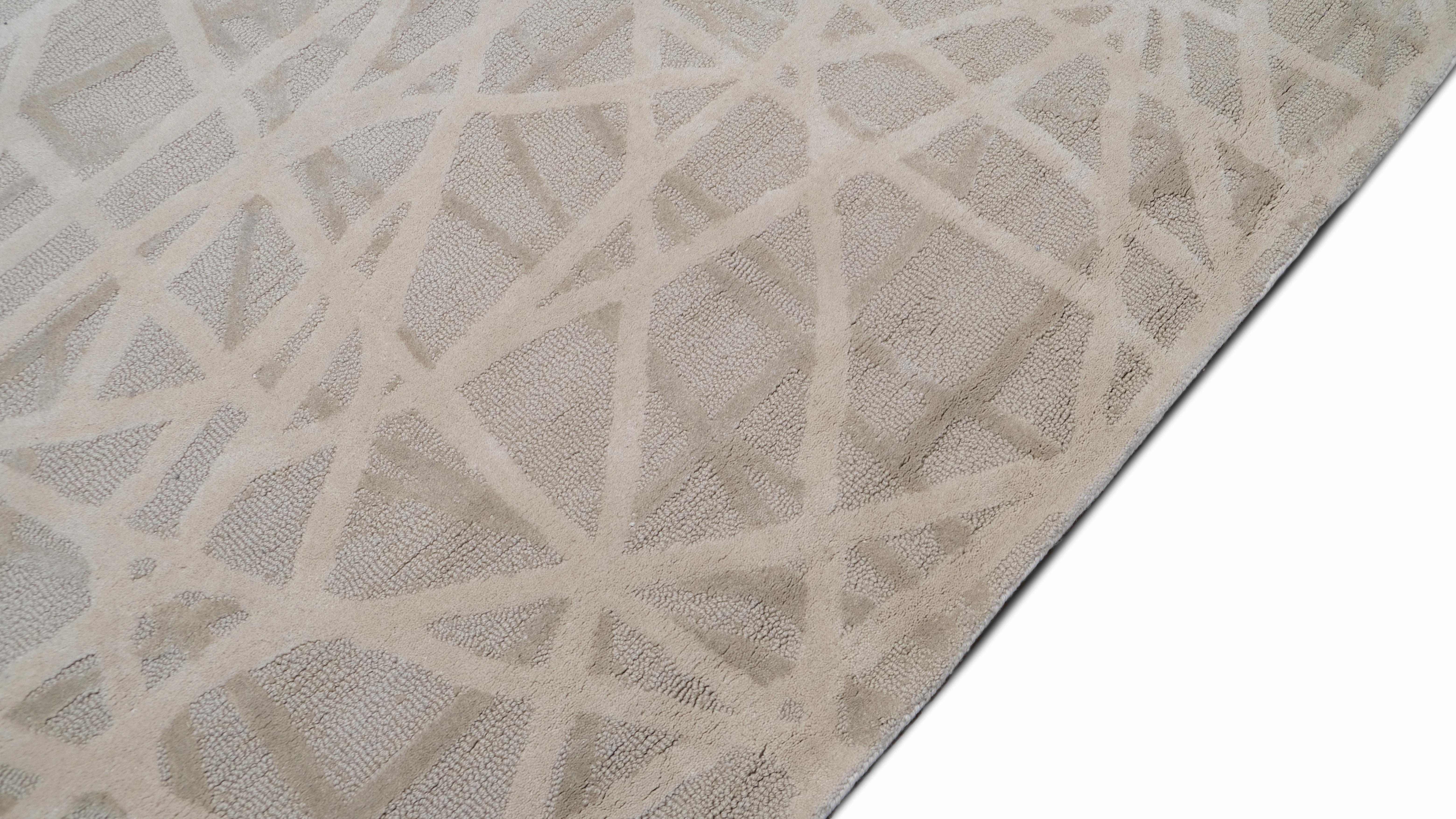 Bringen Sie einen Hauch moderner Eleganz in Ihr Zuhause mit diesem handgetufteten Wollteppich, der ein abstraktes, lineares Design in sanften Beige- und Elfenbeintönen zeigt. Das verschlungene, netzartige Muster erzeugt einen dynamischen visuellen