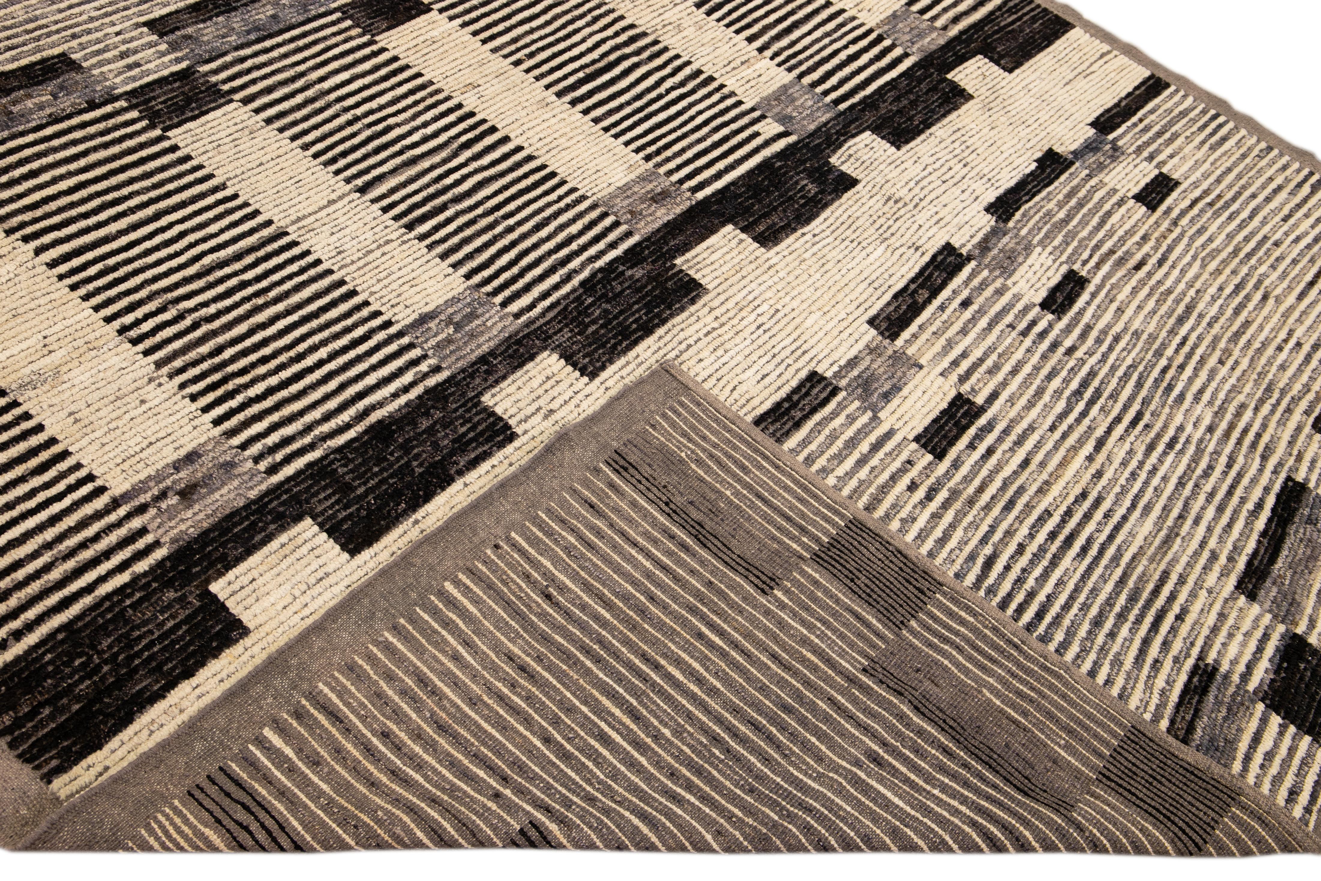 Schöner handgefertigter Wollteppich im marokkanischen Stil mit beigem Feld. Dieser moderne Teppich hat braune Akzente und ein wunderschönes, geometrisches Boho-Muster.

Dieser Teppich misst: 8'4