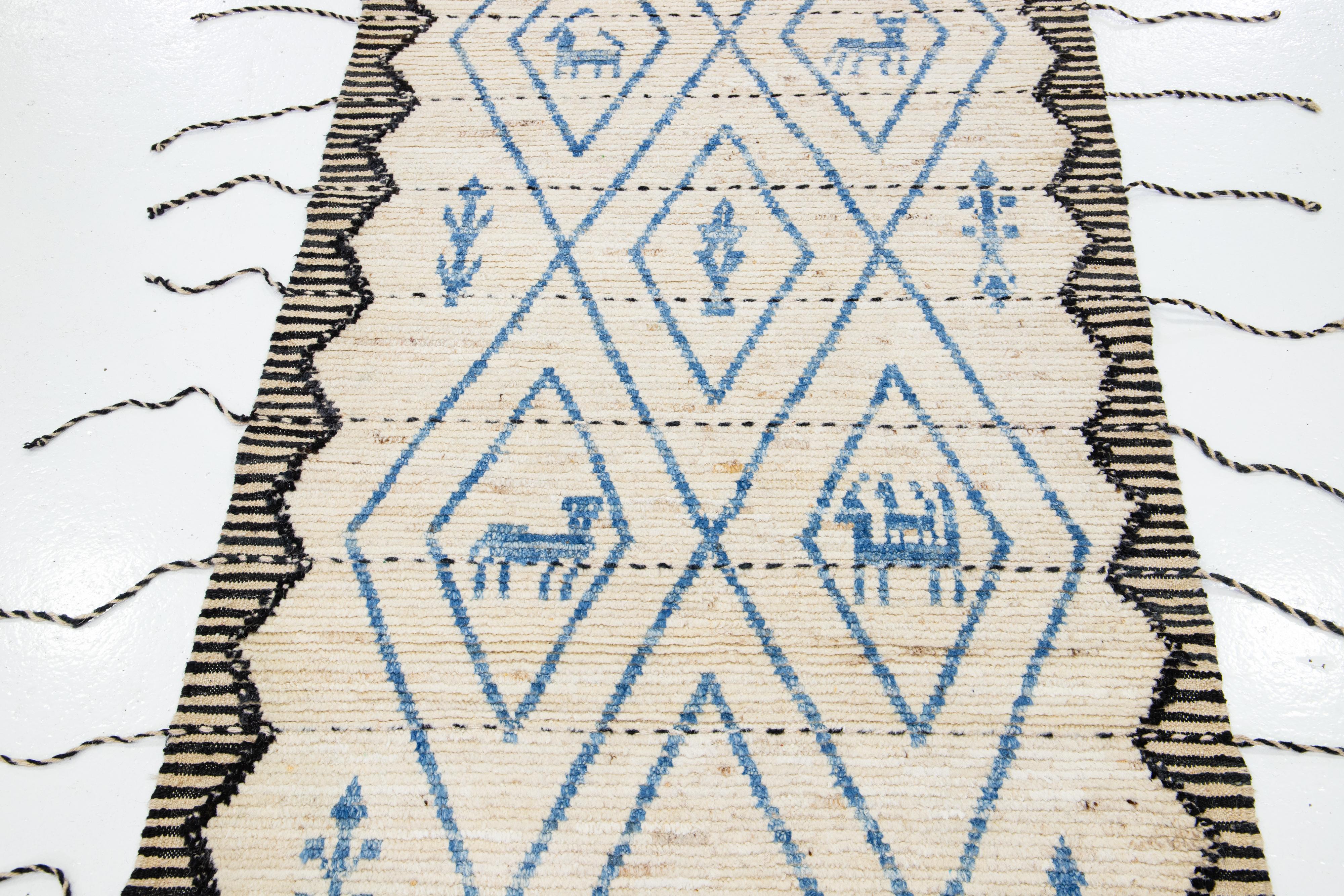 This handcrafted wool runner exhibits a captivating Moroccan pattern. Its modern allure is reflected through a tribal motif, beautifully blending black and blue hues against a mesmerizing beige backdrop.

This rug measures 3'6