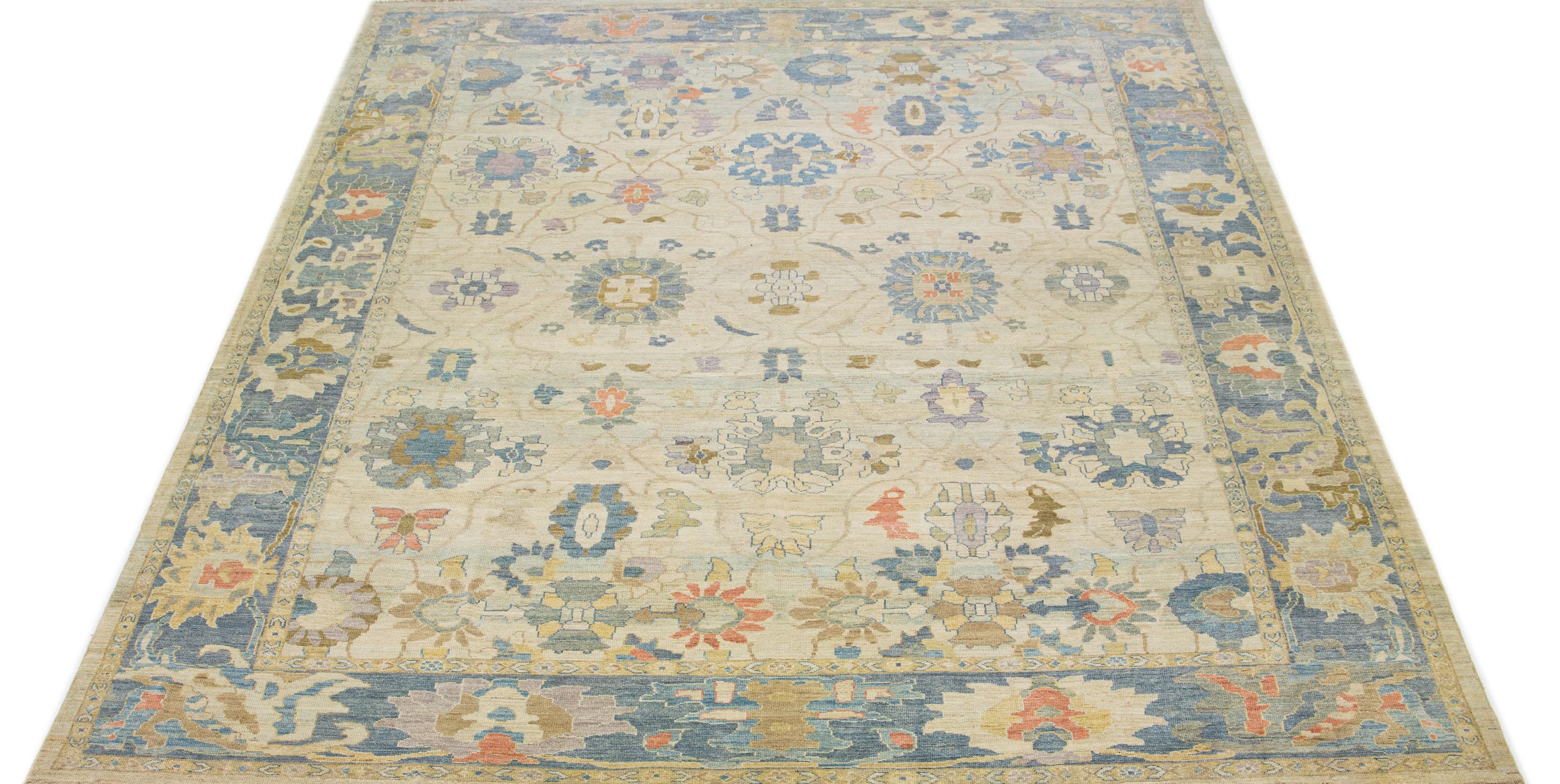 Beautiful modern Sultanabad hand-knotted wool rug with a beige color field. This rug has a navy blue-designed frame with multicolor accents in a gorgeous all-over floral motif.

This rug measures 12'5