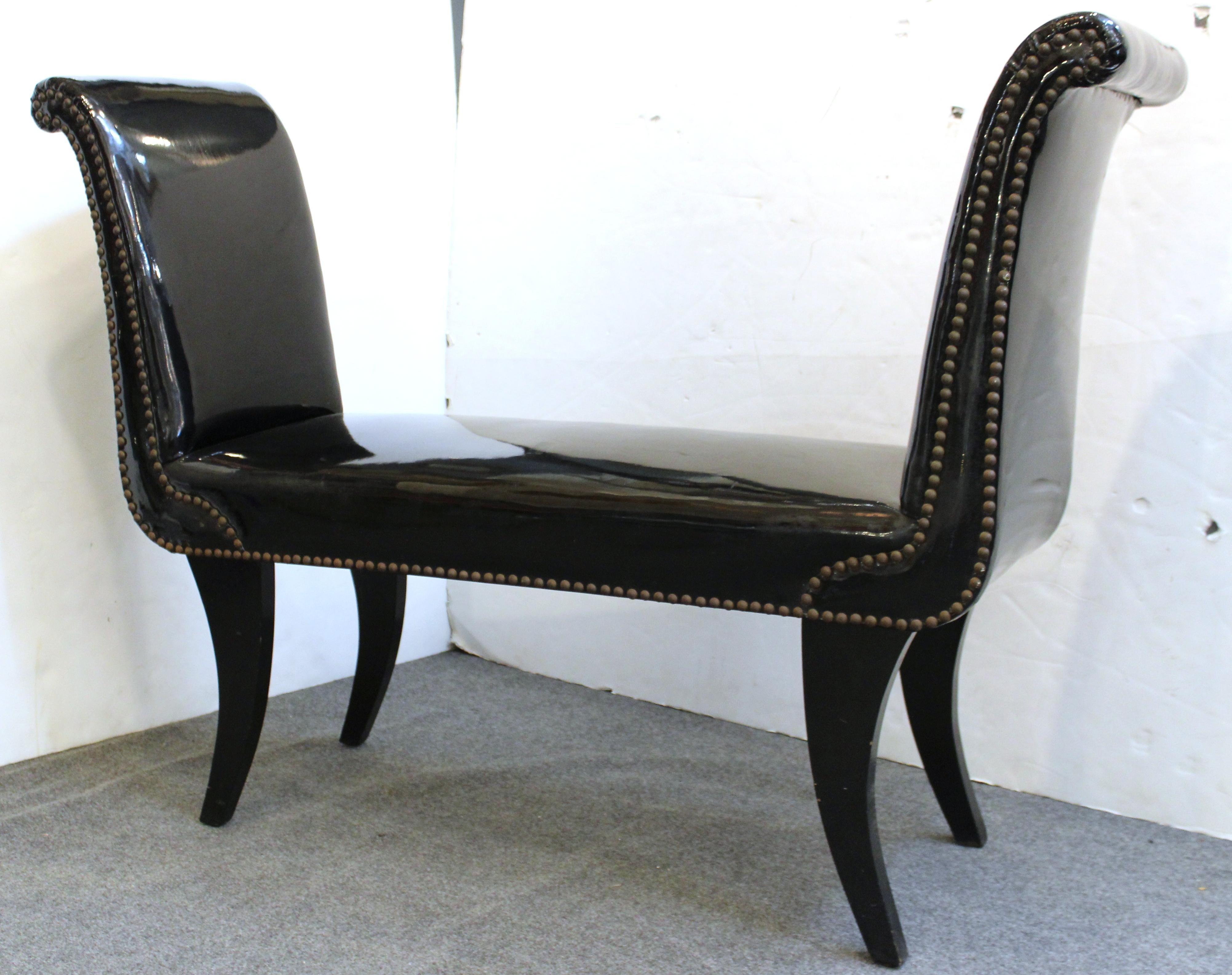 Modern bench with classical lines, upholstered in black faux leather and with ebonized legs. The piece is in good vintage condition, with some minor wear to the upholstered surfaces.