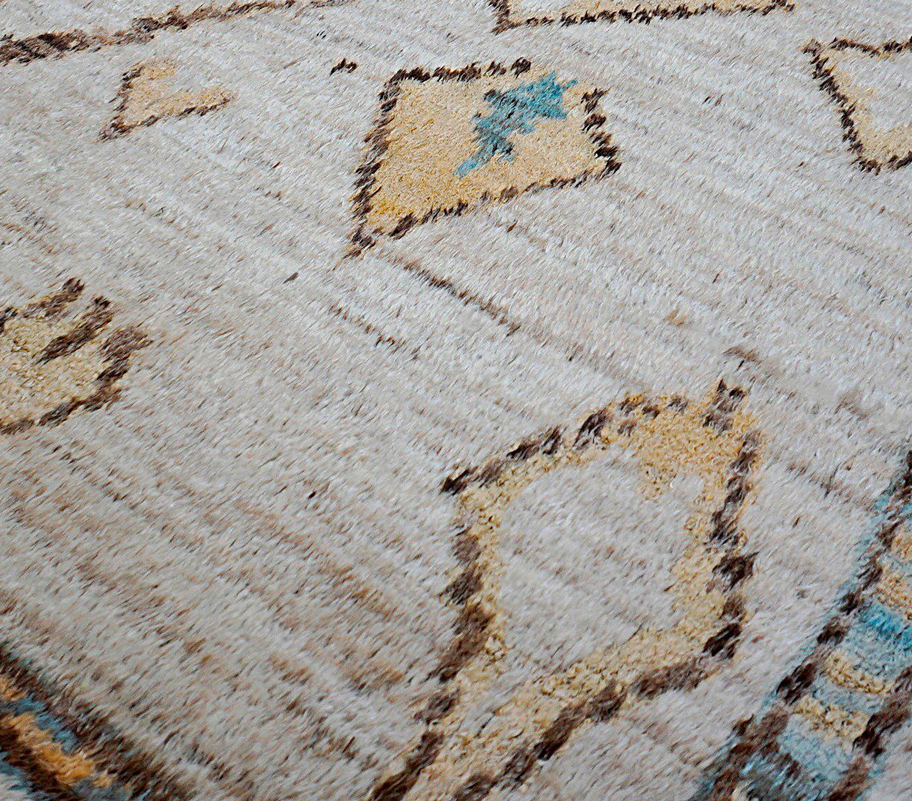 Ce tapis moderne noué à la main allie harmonieusement l'art tribal traditionnel et les sensibilités du design contemporain. Confectionnée en laine de première qualité filée à la main, cette pièce présente un motif géométrique minimaliste inspiré