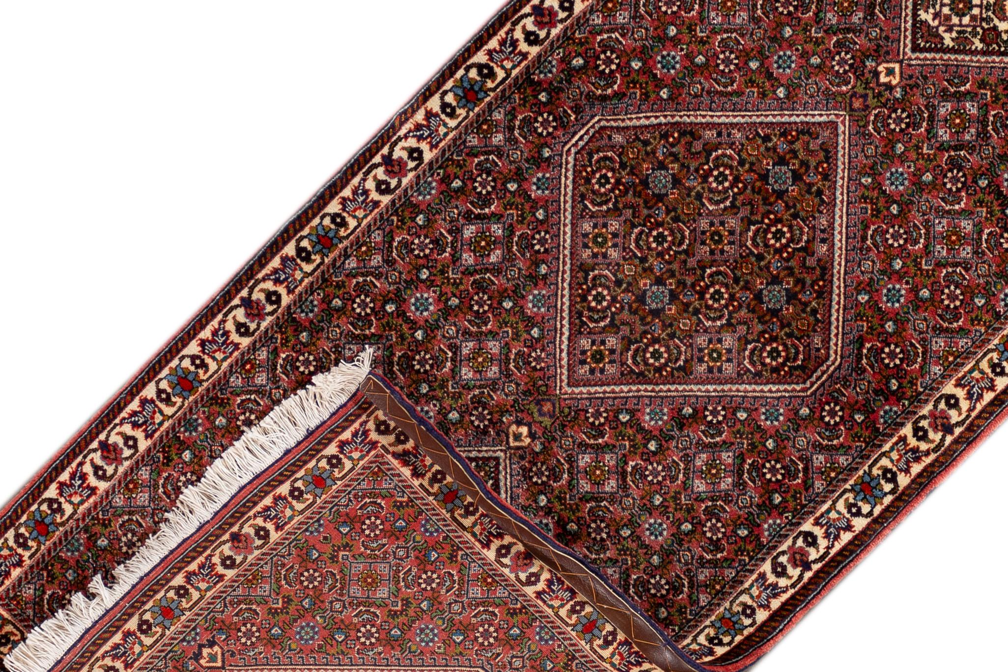 A 21st century modern Bidjar rug with a red geometric multi-medallion motif. This rug measures at 2'6