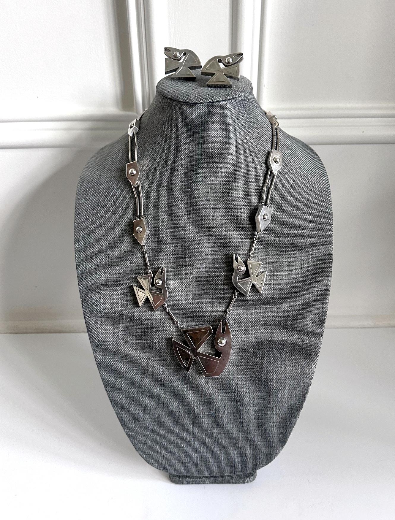 Eine sehr skulpturale Schmucksuite aus Sterlingsilber, bestehend aus einer Halskette mit Vogelmotiv und einem passenden Paar Ohrringe. Das dreiteilige Set wurde von der peruanischen Silberschmiedin und Designerin Grazielle Laffi (1923-2009), Lima,