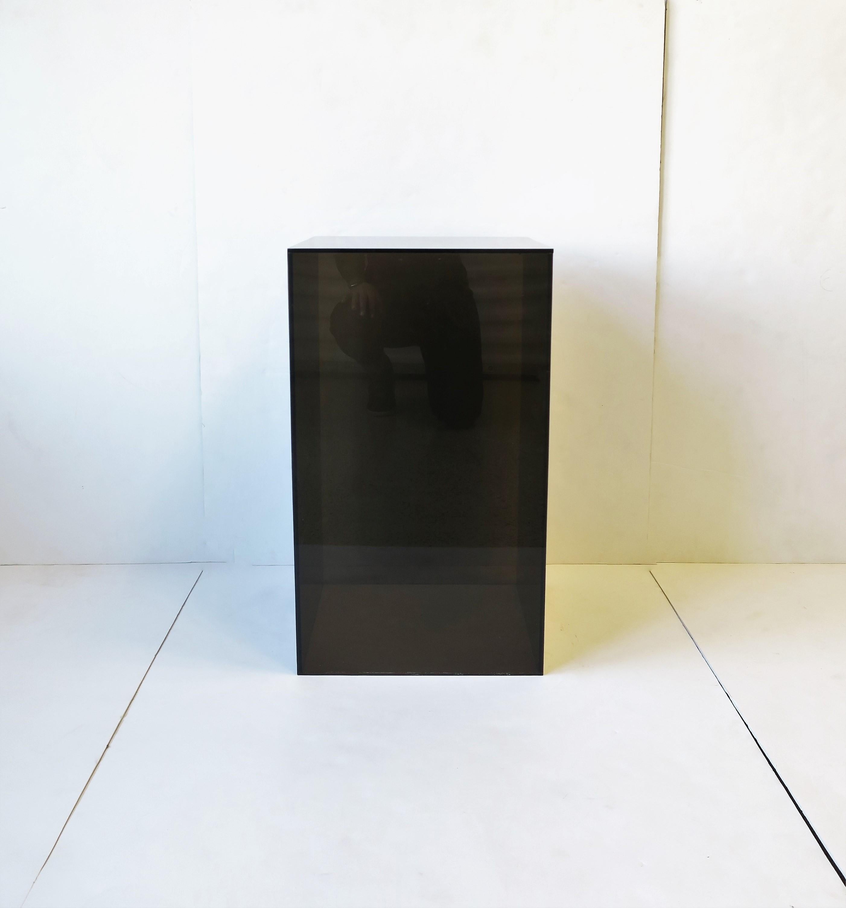 A modern or Postmodern period black acrylic pedestal column stand display piece or end table, circa late 20th century. Great for items such as art, sculpture, jewelry display, plant, and more. Or as and end table as demonstrated with books and table