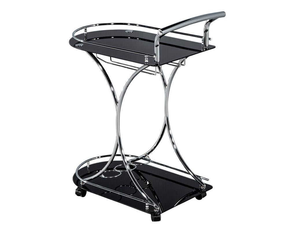 Introducing the ultimate addition to your modern home bar: the sleek and elegant black and metal bar cart trolley. Crafted with a polished metal frame and back painted black glass, this bar cart exudes sophistication and contemporary style. The