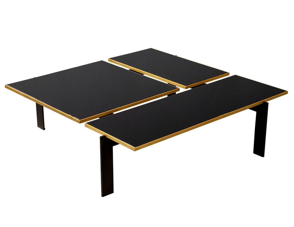 Modern black cocktail table by Baker Blade Thomas Pheasant. Featuring black back painted three-piece glass top with light bronze and oiled bronze trim and base
Price includes complimentary curb side delivery to the continental USA.