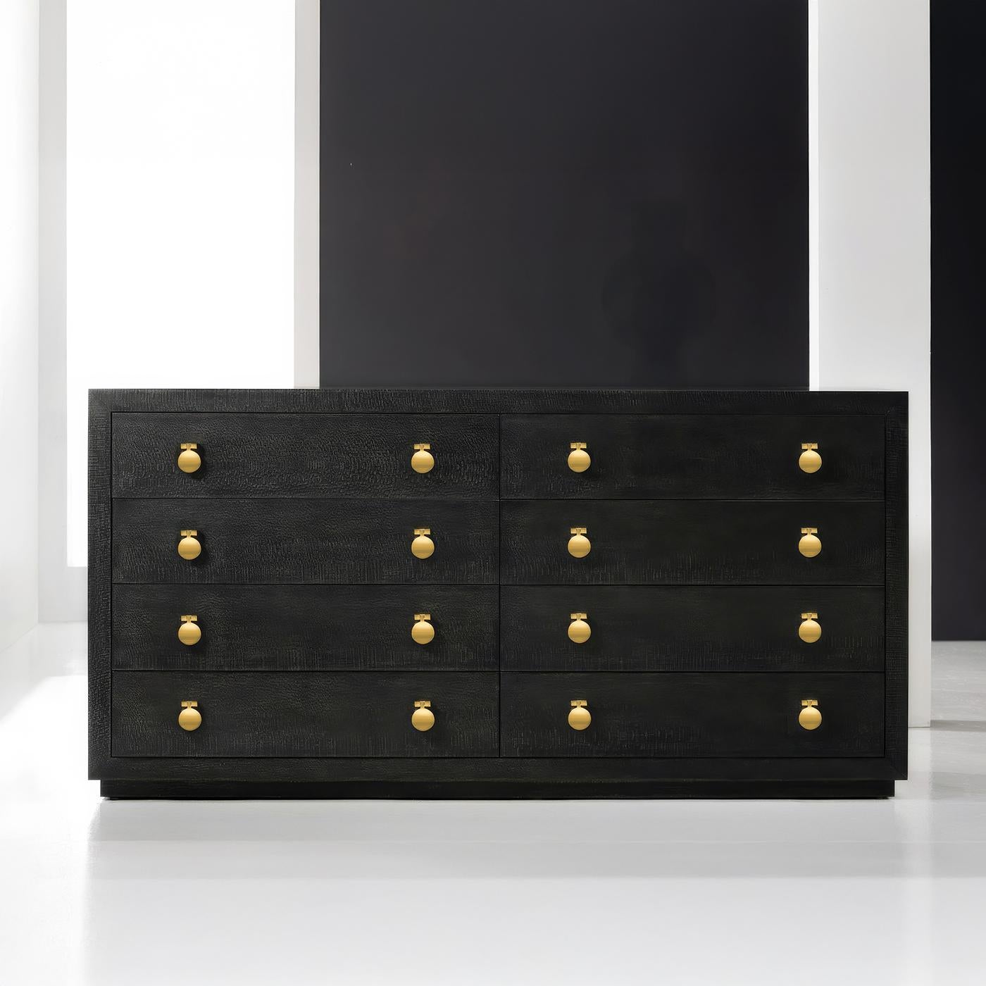 La quincaillerie en laiton poli met en valeur la texture distinctive du placage de bois de laurier noir, rehaussée par une finition ébène profonde. Le design épuré comporte huit tiroirs, chacun orné de poignées contemporaines en laiton qui offrent