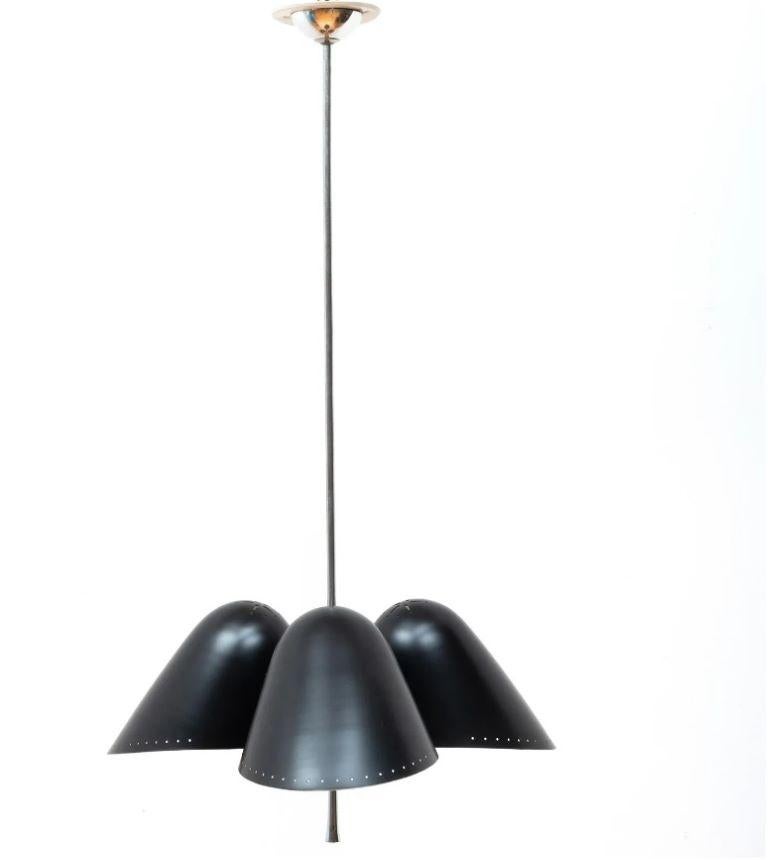 Modern black enamel and chrome three-light pendant. Three black enamel shades in a cluster around a ball at the bottom of chrome rod; each shade has perforated detail along the border. Will need to be rewired for use.
