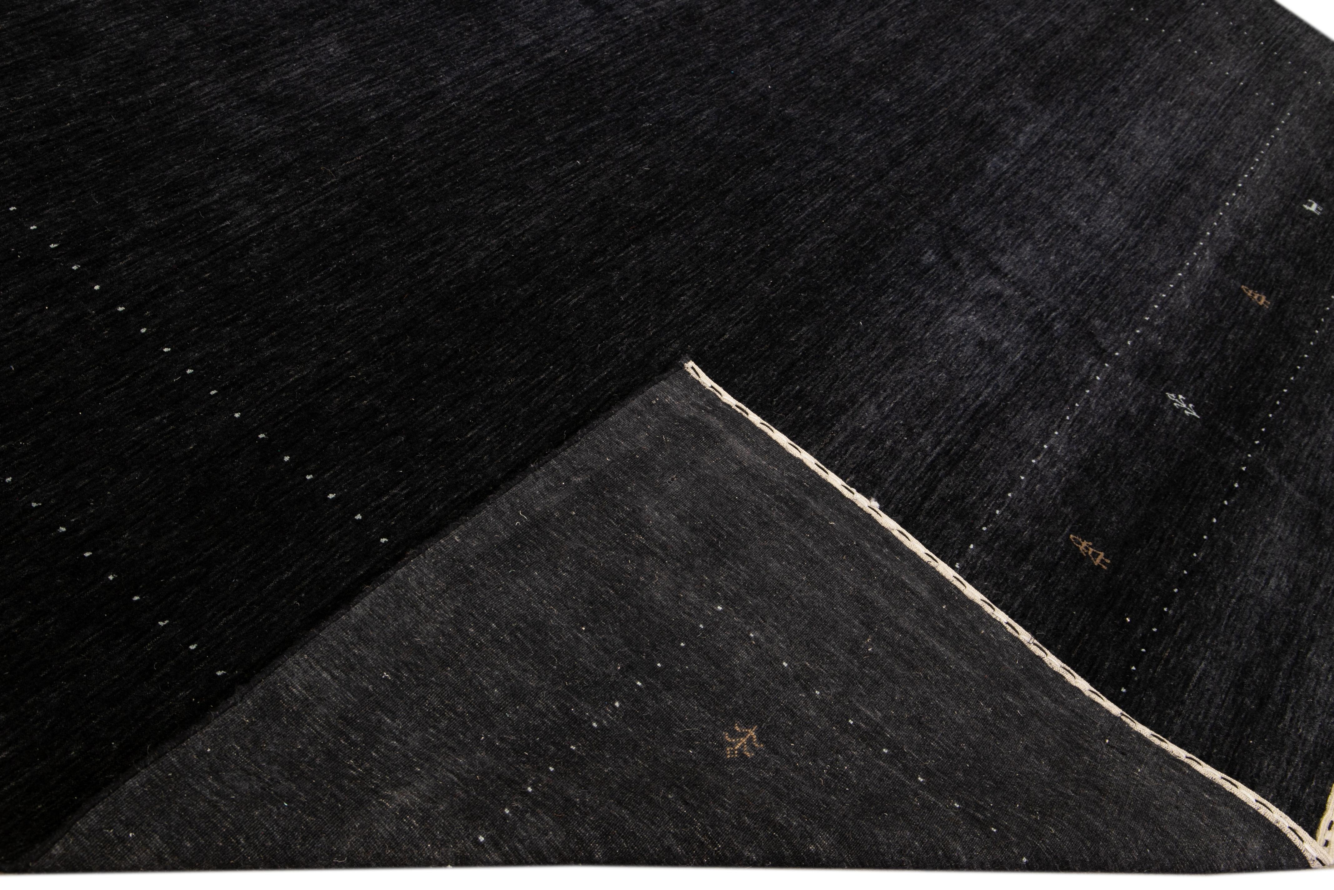 Magnifique tapis moderne en laine tissée à la main de style Gabbeh avec un champ noir. Ce tapis de style Gabbeh présente des accents bruns et blancs dans un magnifique motif géométrique minimal.

Ce tapis mesure : 11'10