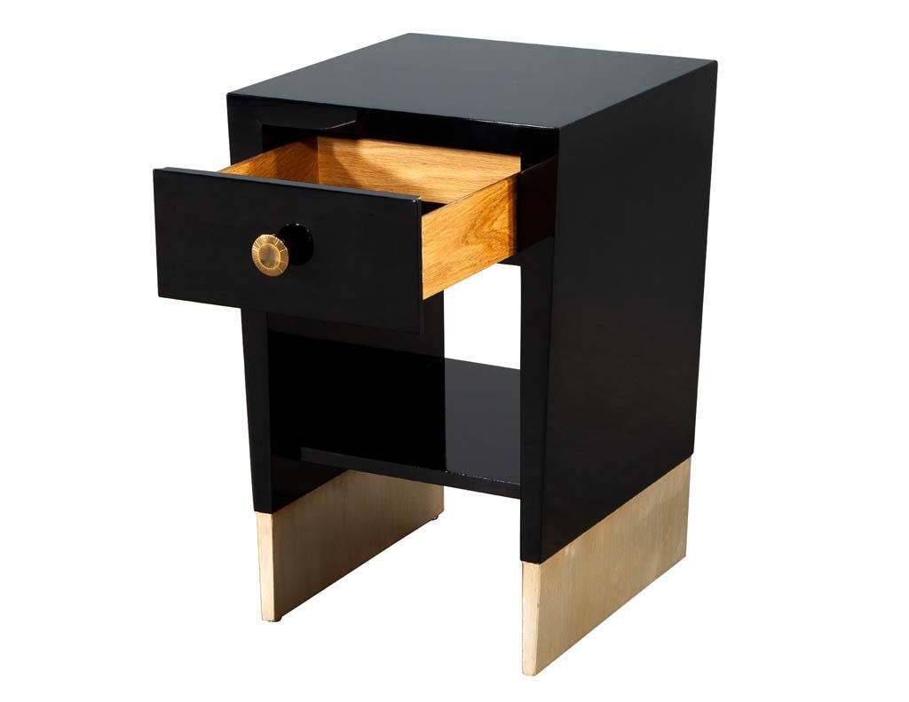 Modern Black Lacquered End Table by Jacques Garcia Baker Furniture. Sleek modern design in hand polished black lacquered finish. Featuring brass plated round hardware and gold leafed base. Matching end table in larger size available and sold