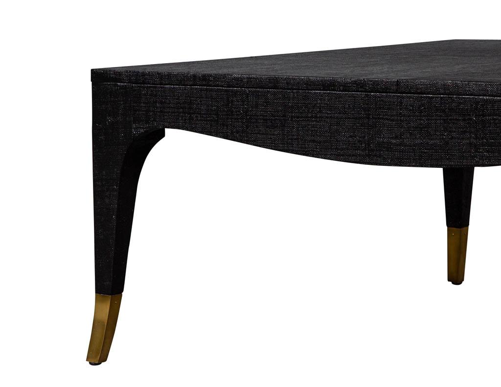 Table basse moderne recouverte de lin noir. Il se caractérise par des lignes courbes et épurées et des pieds en laiton.

Le prix comprend un service gratuit de livraison en bordure de trottoir dans la zone continentale des États-Unis.