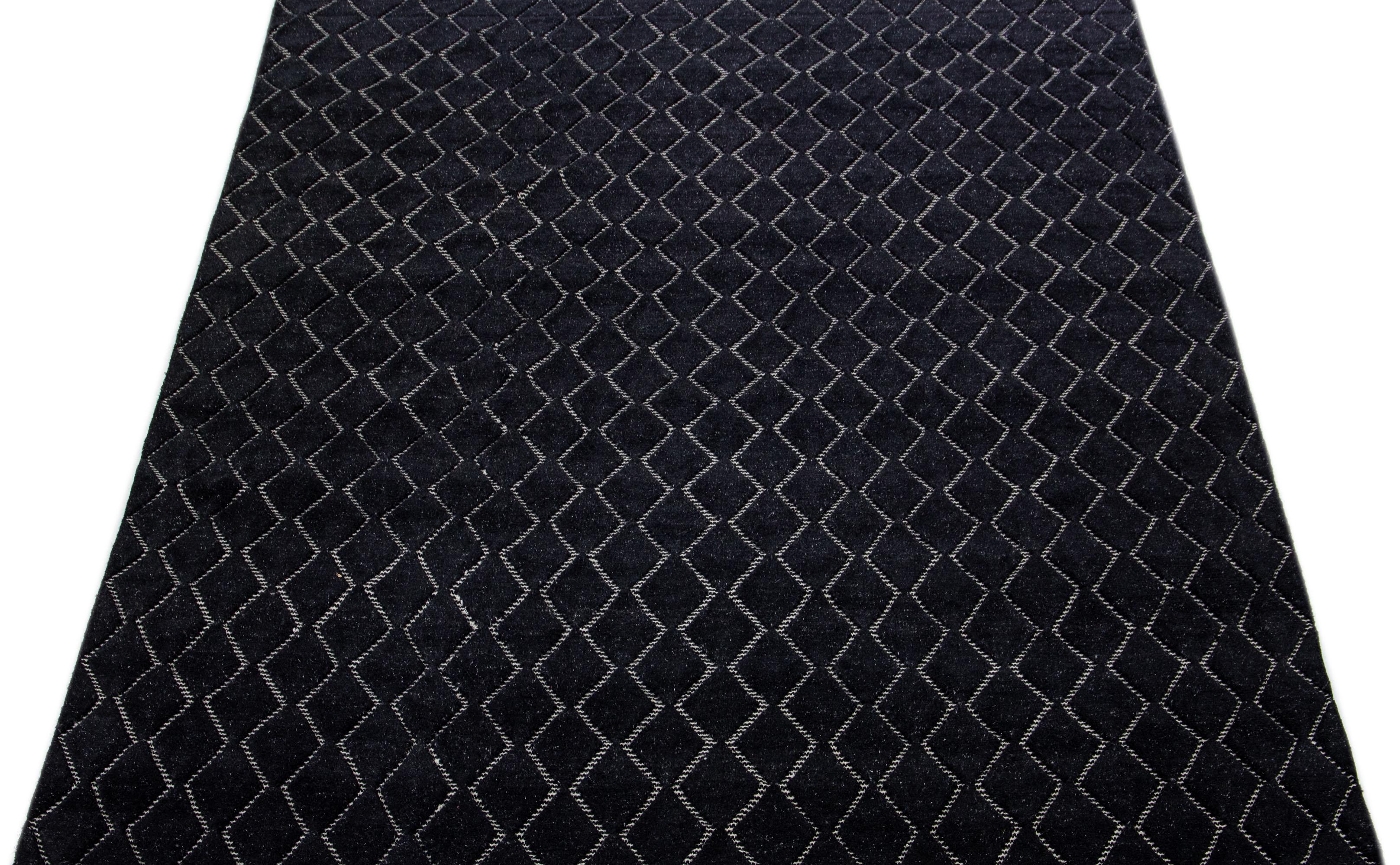 Ein zeitgenössischer marokkanischer Teppich mit einem aufwendigen geometrischen Allover-Muster, das von Hand geknüpft wurde, vor einem Hintergrund in elegantem Schwarz.

Dieser Teppich misst 9'3