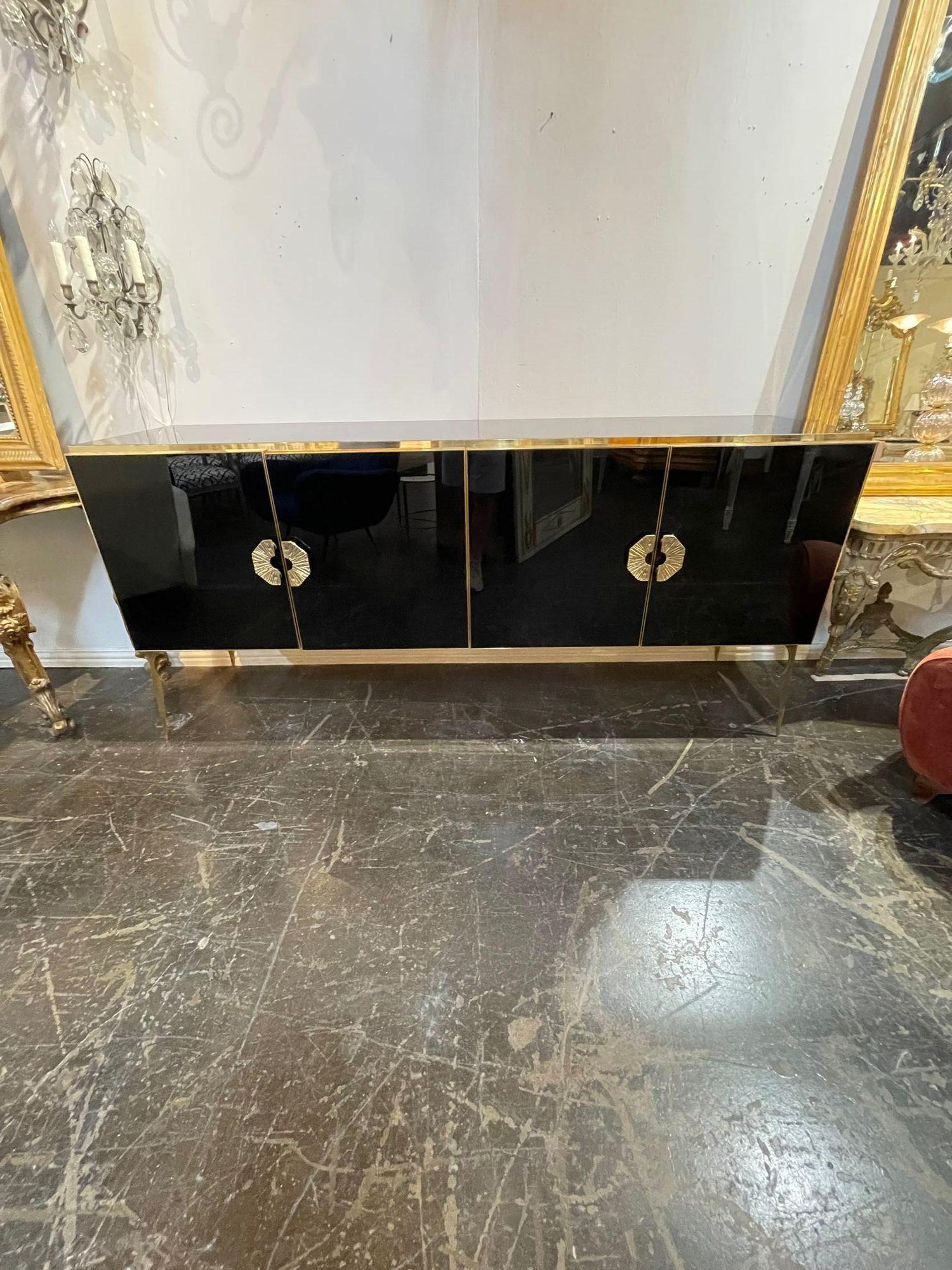 Exquisite modern black Murano glass sideboard with polish brass. This piece has 4 doors and tons of storage inside. Functional and beautiful.  Truly outstanding!