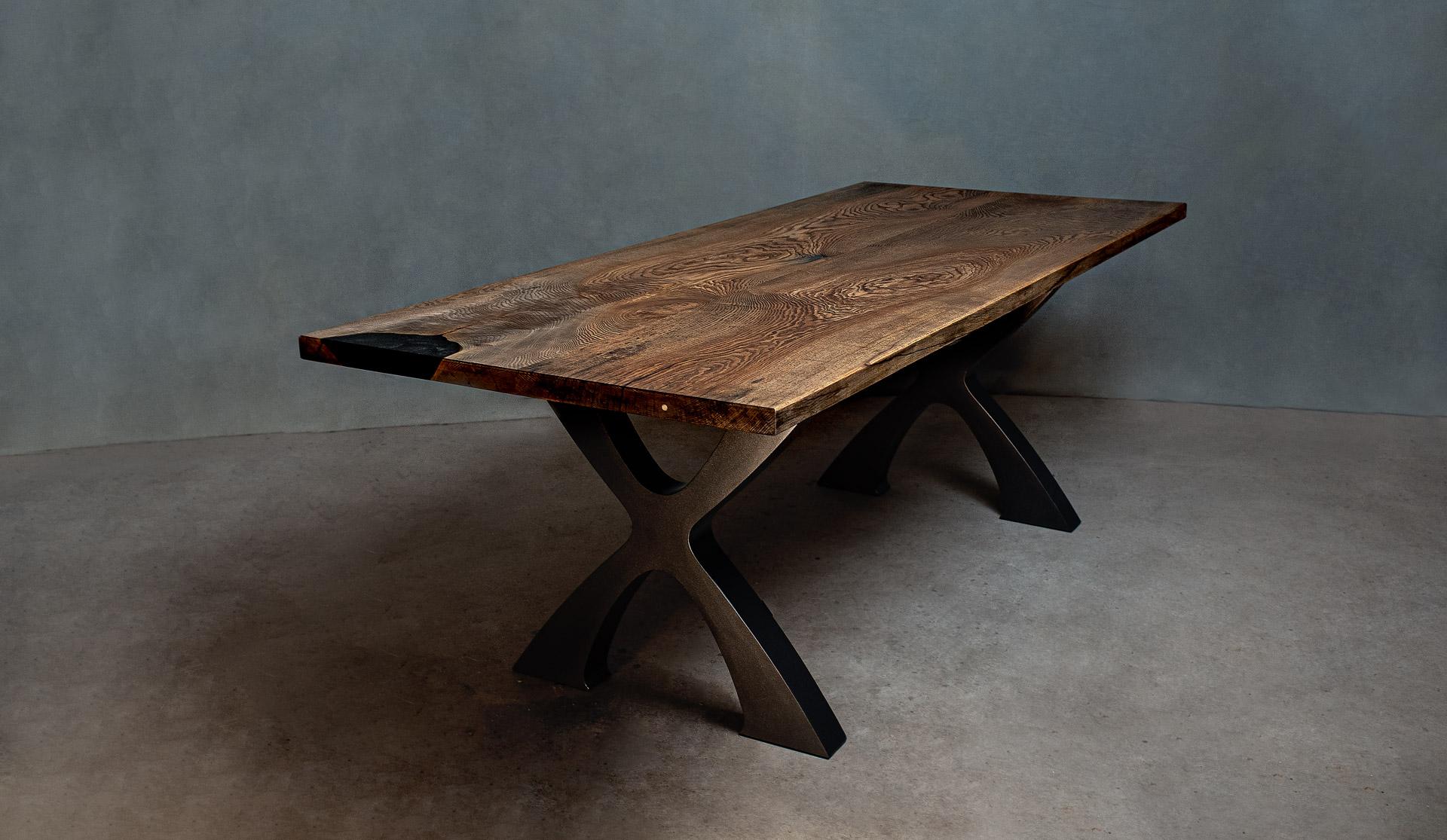 A 6-seater black oak dining table with modern X-shaped table legs. 
The leg finish is a durable powder coat.

Normally a native American tree, this black oak was found in western Sweden.

The table is available immediately.