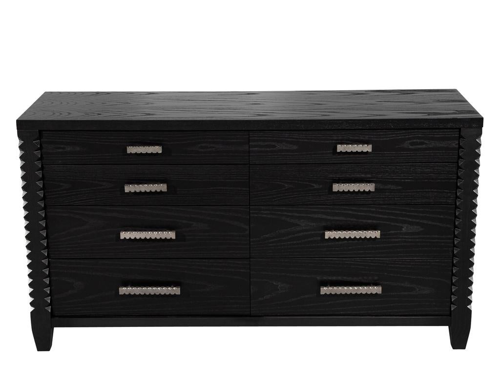 Introduce un almacenamiento sofisticado en tu espacio con este moderno armario vestidor. El rico acabado en tinte negro carbón resalta maravillosamente las vetas naturales de la madera de roble. Los exclusivos detalles tallados del borde delantero y