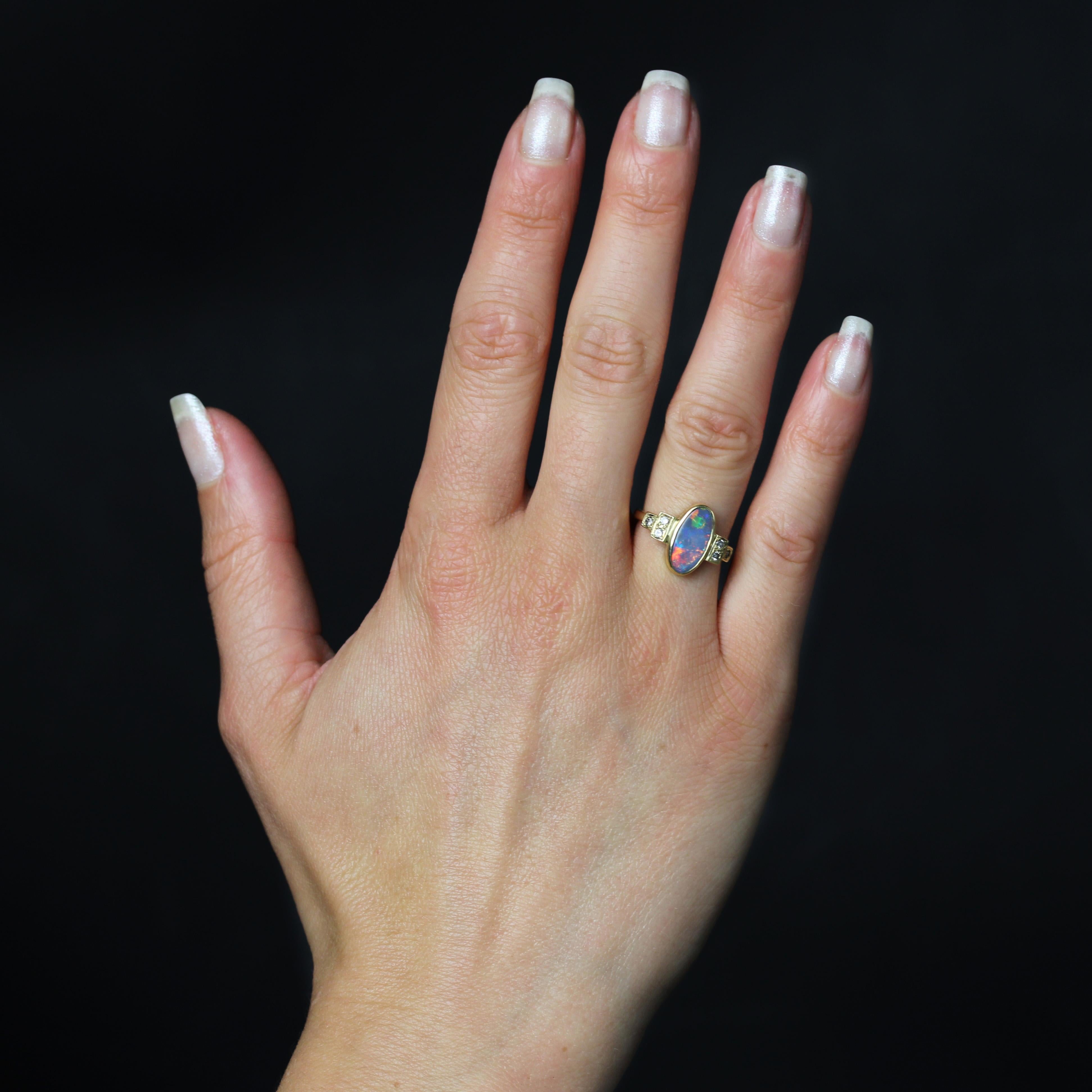 Ring in 18 karat yellow gold.
A contemporary yellow gold ring set with an oval cabochon black opal. On either side, at the start of the ring, 2 x 3 modern brilliant-cut diamonds are set in a stepped design.
Total weight of the opal : 0,78 carats