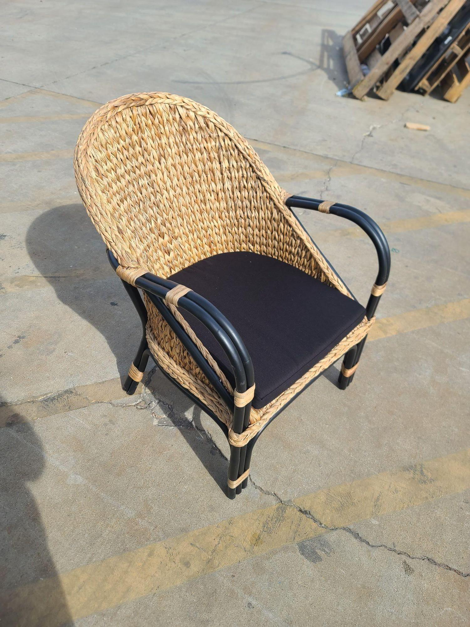 Black rattan Armchair/dining chair with natural wicker fan seat including a cotton upholstery seat cushion. The chair features a chic 1990s Modern design with natural colored Wicker wrapped and a period two-tone look. 
New-Old-Stock, Available 8,