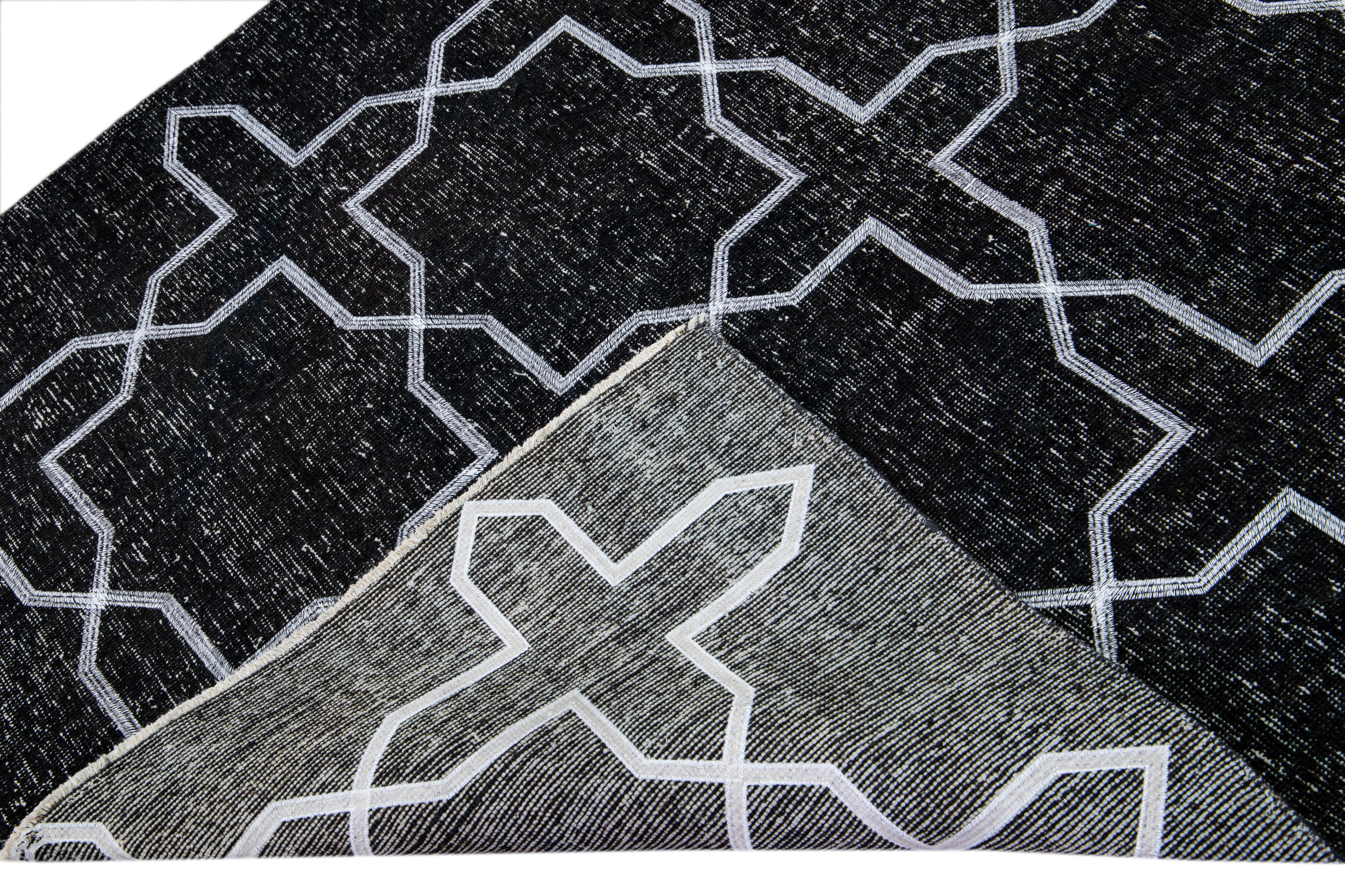 Beautiful Turkish handmade wool rug with a black distress look field. This Modern rug has white accents featuring a gorgeous all-over geometric pattern design.

This rug measures: 4'10