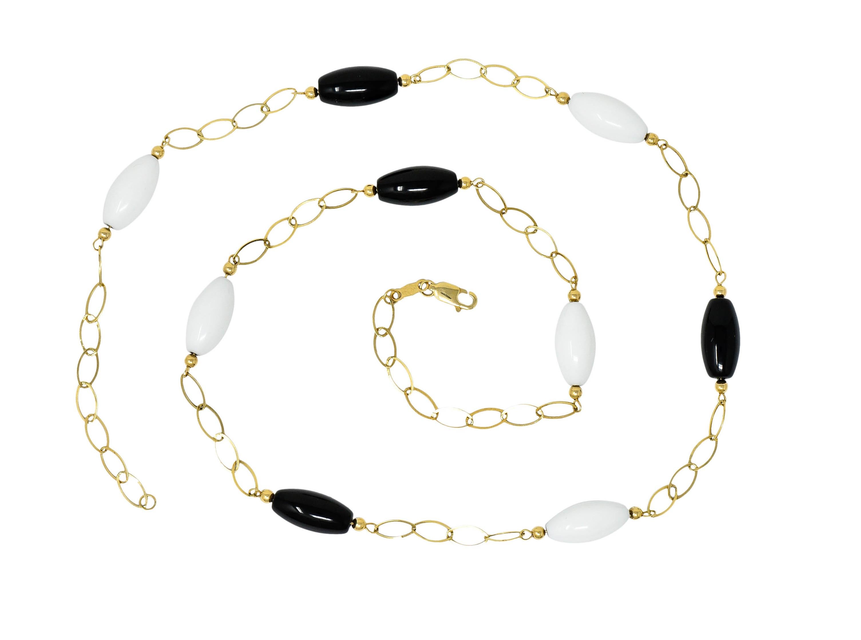 Necklace is comprised of polished gold oval links

With nine agate bead stations evenly spaced throughout

Alternating opaque black and white color

Completed by a lobster clasp

Maker's mark and stamped 14K for 14 karat gold

Circa: 2000s

Length: