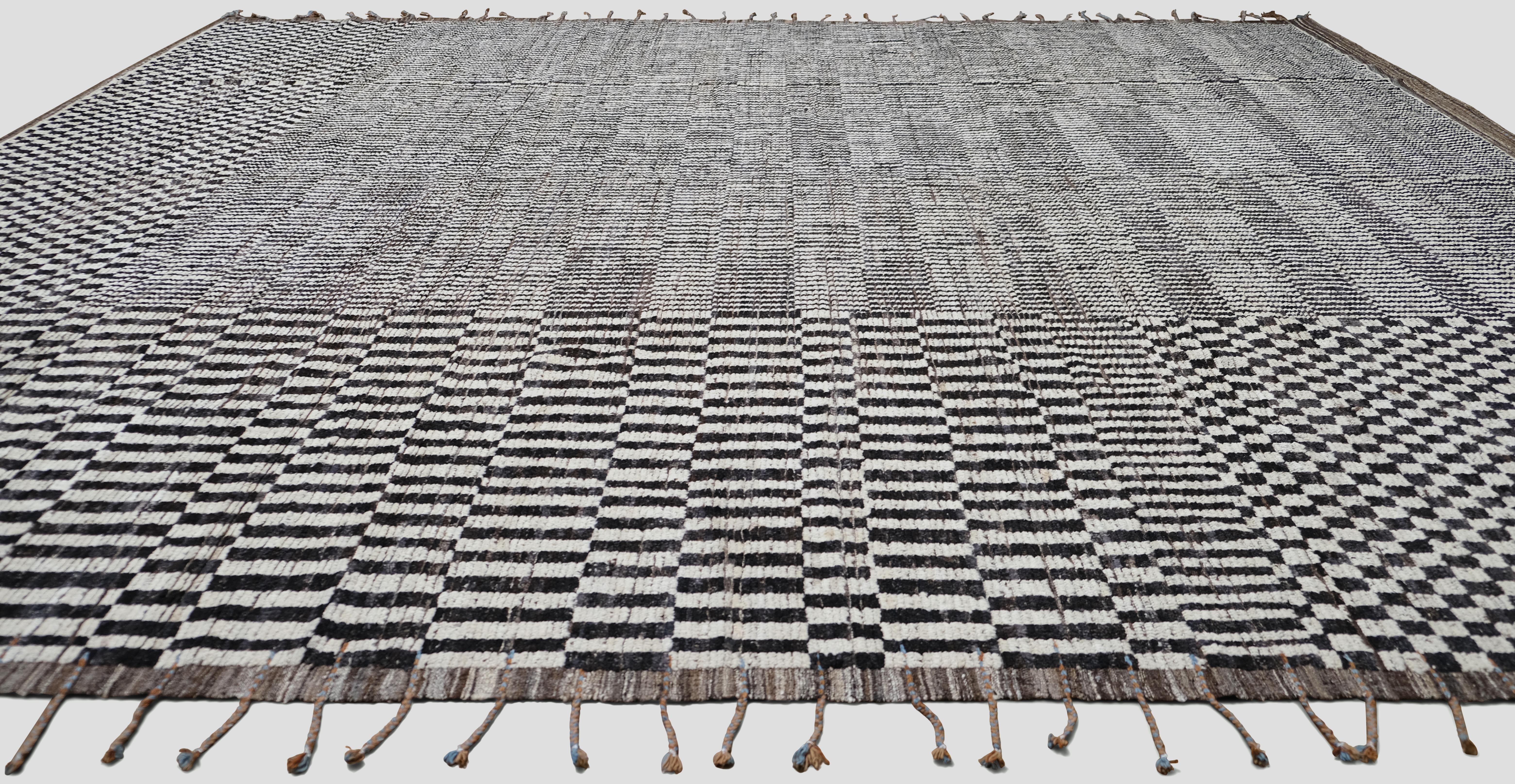 Dieser handgeknüpfte Wollteppich zeigt ein auffälliges geometrisches Muster in Braun, Schwarz und Weiß, das modernen Minimalismus mit traditioneller Handwerkskunst verbindet. Die komplizierten Schachbrett- und Linearmuster erzeugen ein dynamisches