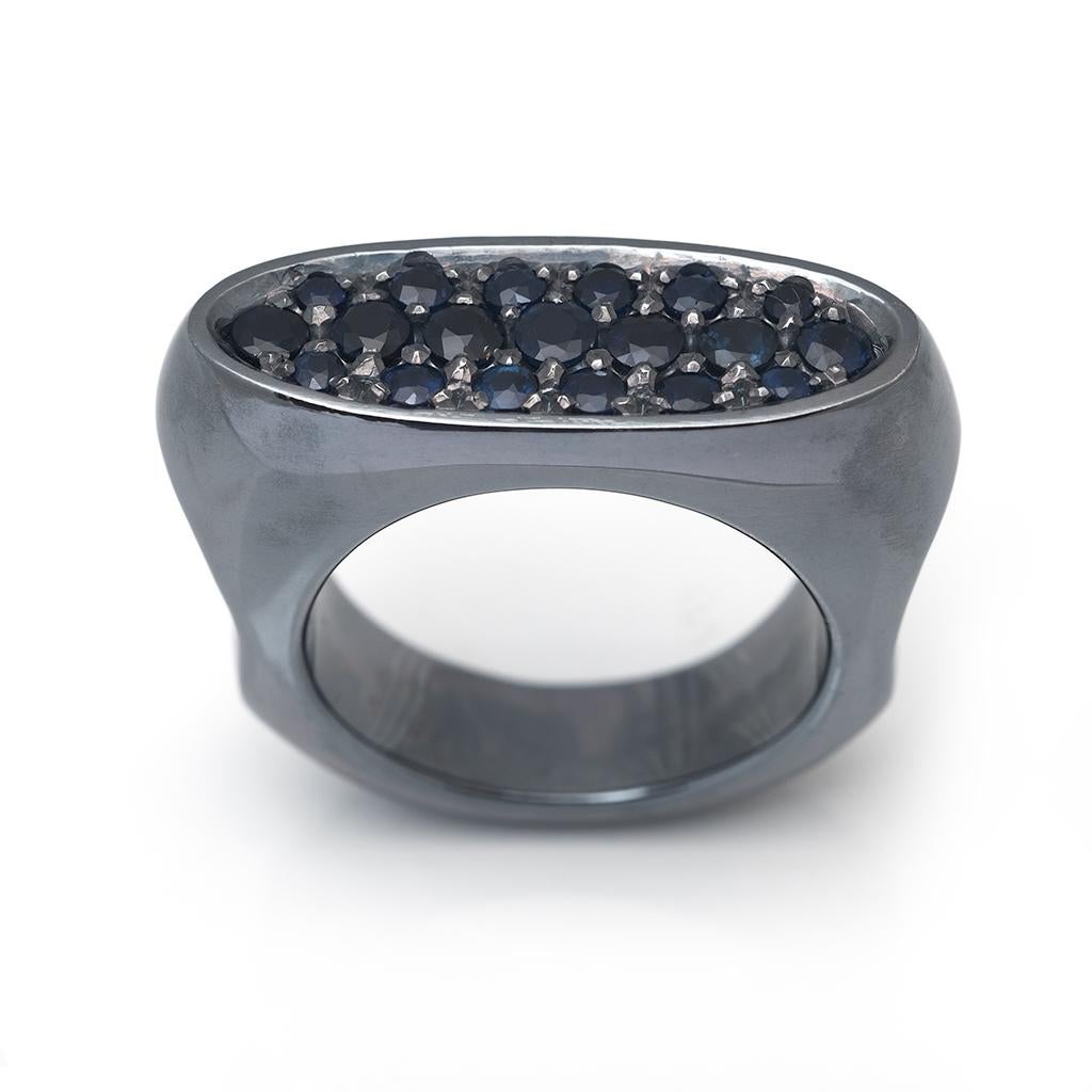 Blue Sapphires have been set into blackened sterling silver ring. 
The sapphires sparkle in this moody ring. The ring features a Biomorphic design to fit comfortably on your finger. 
This ring is bold and striking. A unique piece of jewellery that